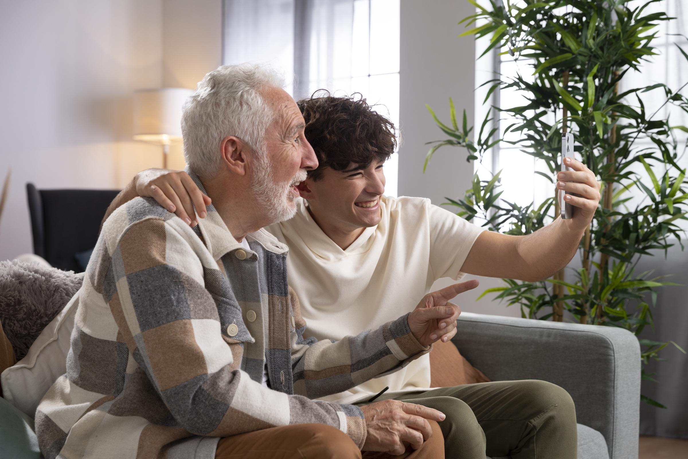 Un nieto haciéndose una foto con su abuelo | Fuente: Freepik