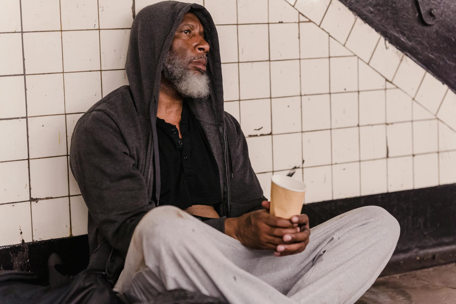 Un indigente con un vaso de papel en la mano | Fuente: Pexels