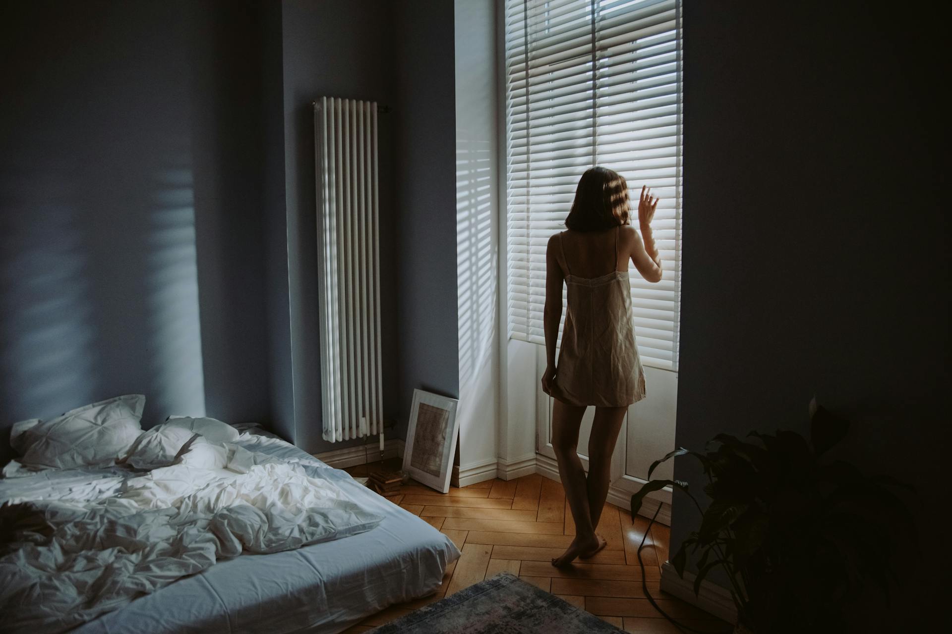 Una mujer junto a las contraventanas de su dormitorio | Fuente: Pexels