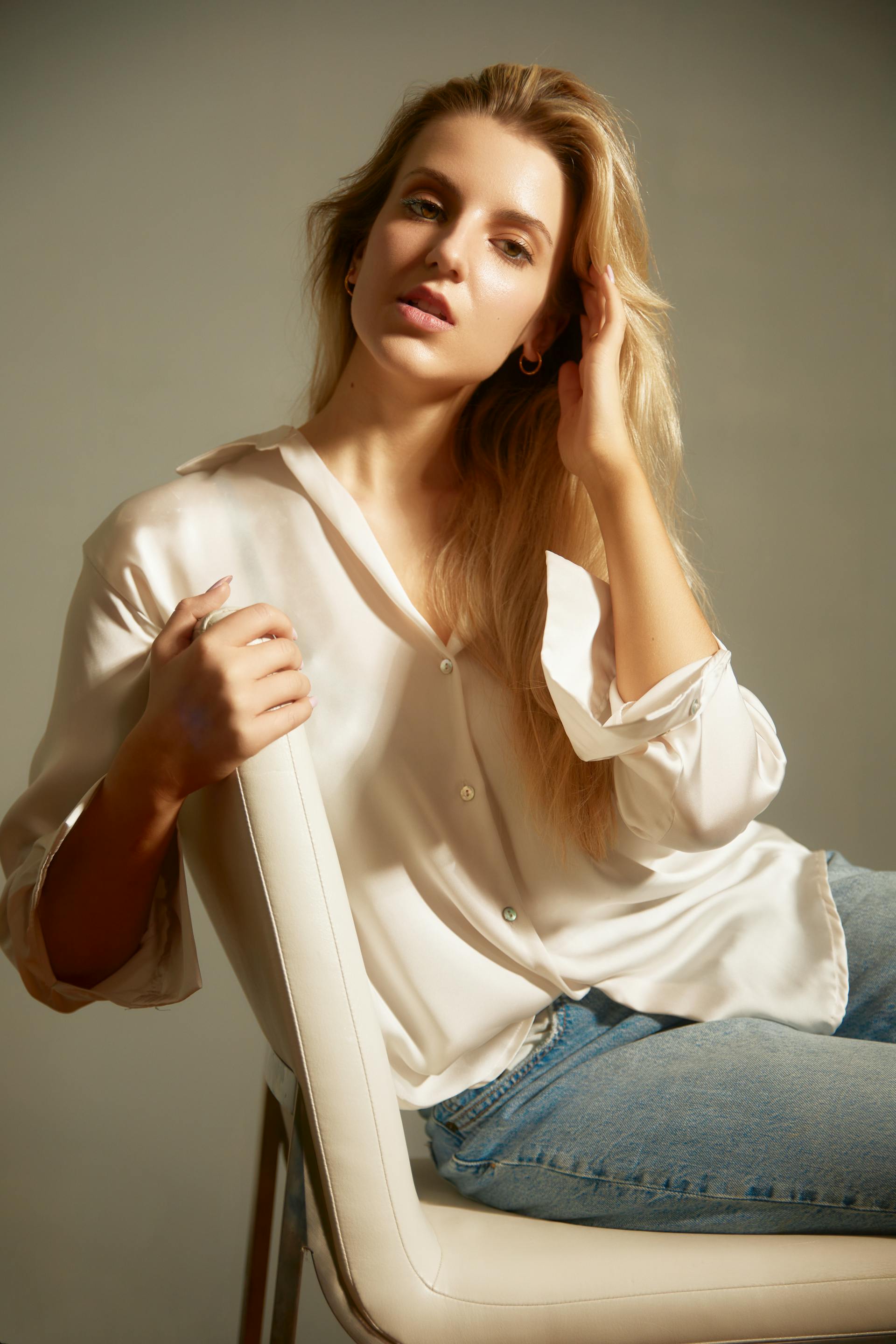 Una mujer sentada en una silla blanca | Fuente: Pexels