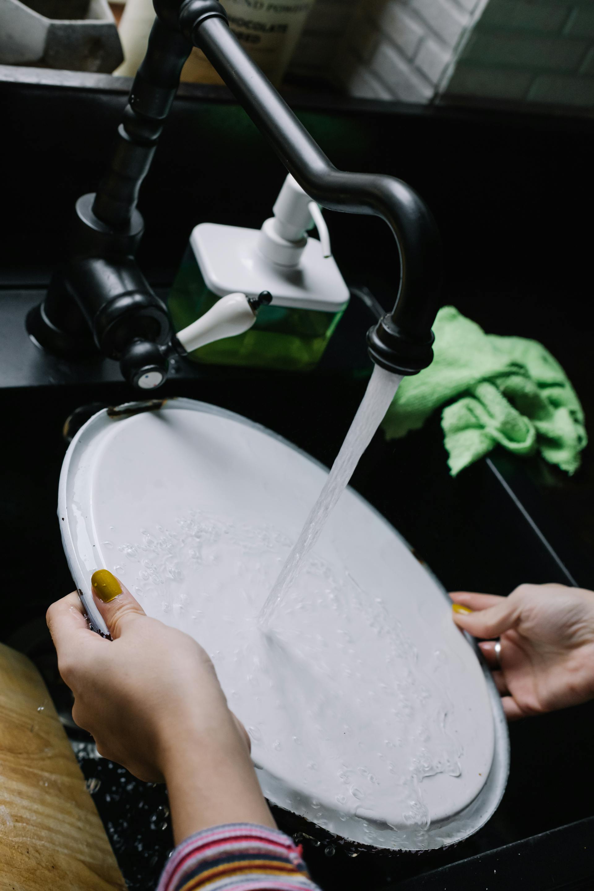 Una mujer lavando un plato | Fuente: Pexels