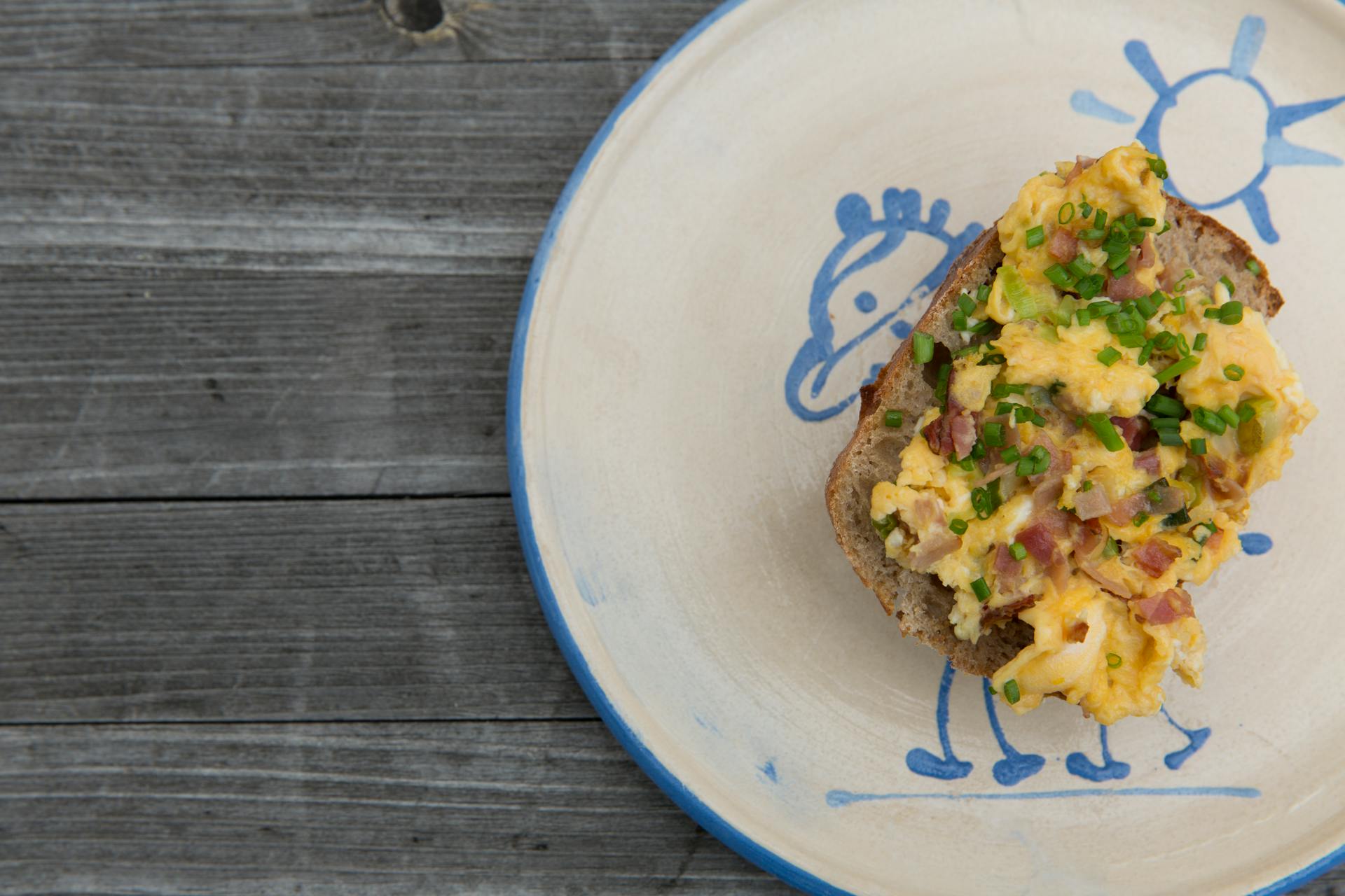 Una rebanada de pan y huevos revueltos servidos en un plato | Fuente: Pexels