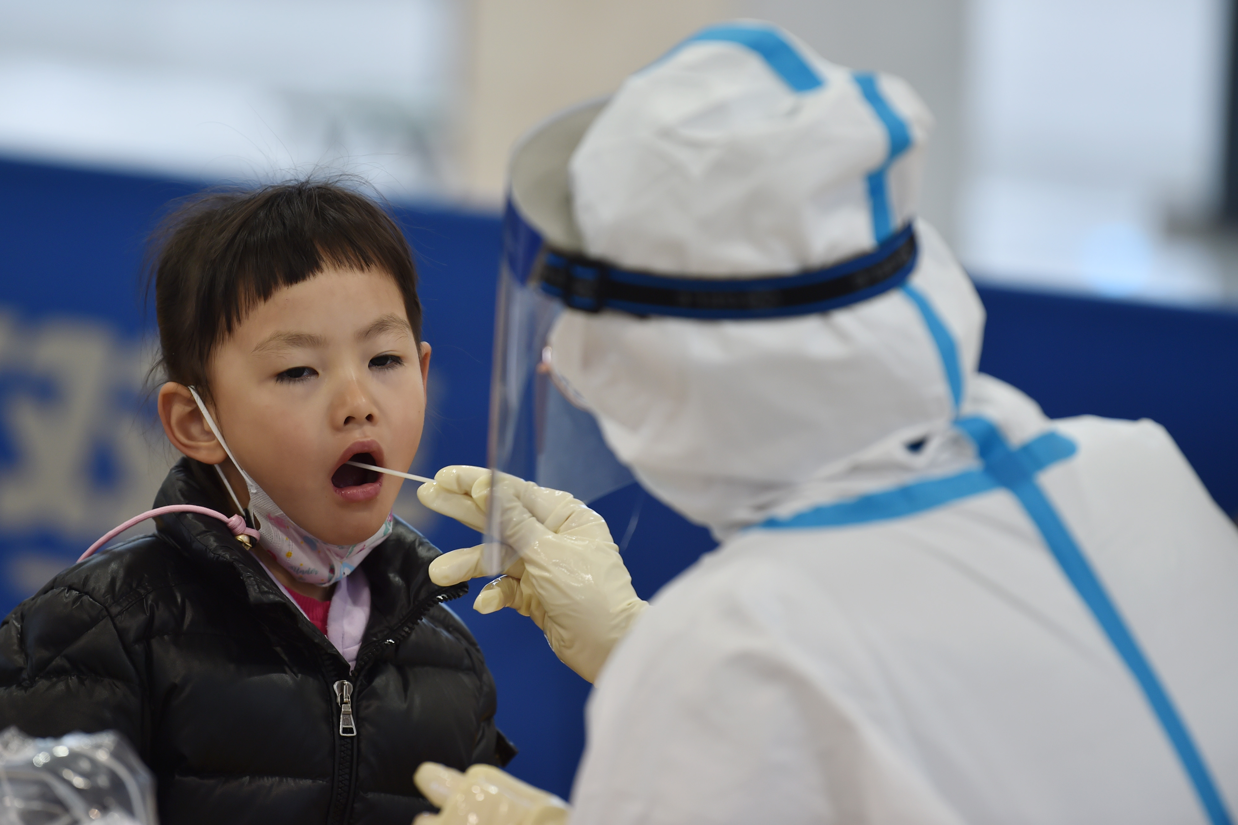 Un trabajador médico toma muestras de la garganta de un niño | Fuente: Getty Images
