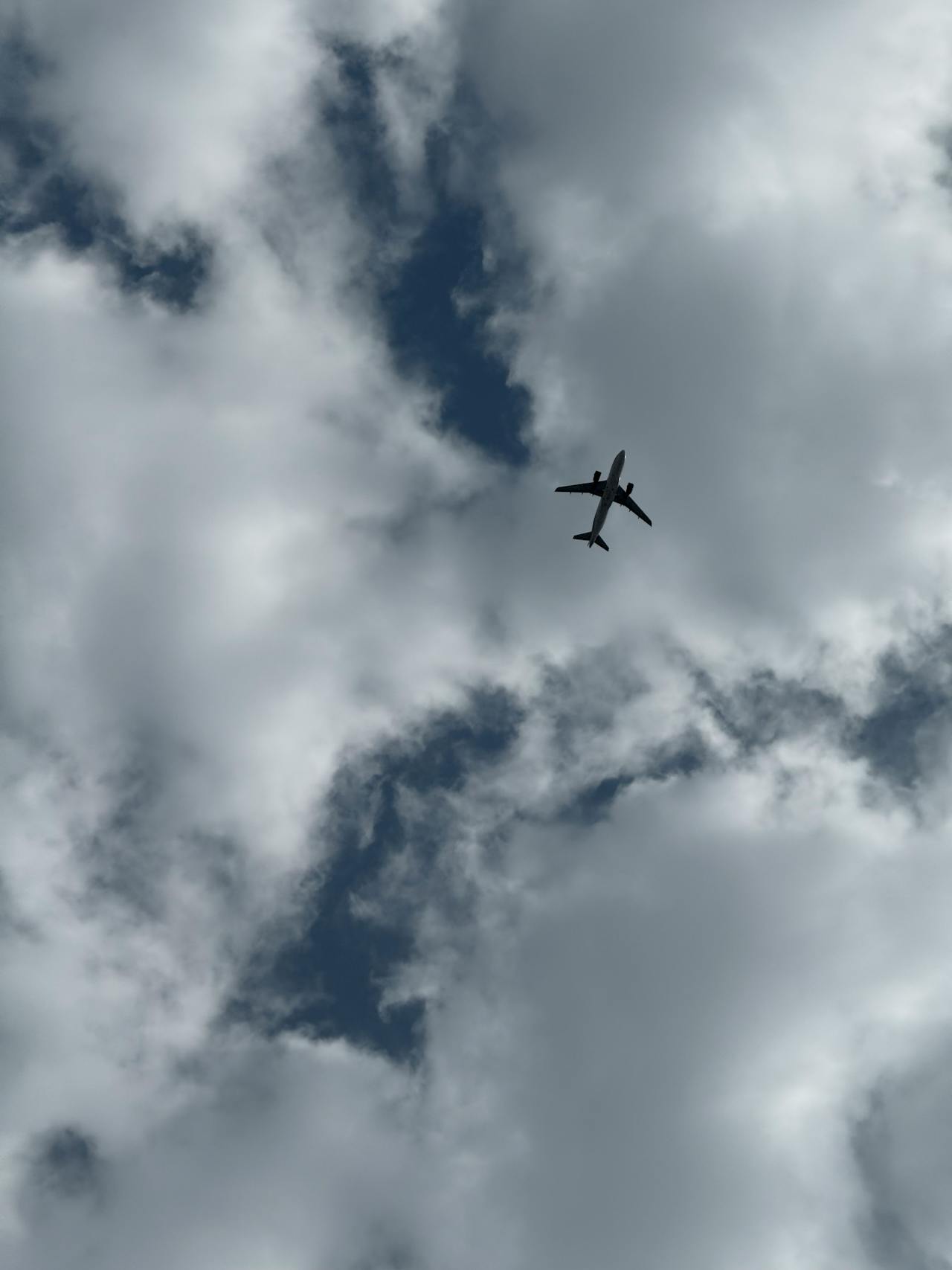 Un avión sobrevolando un cielo nublado | Fuente: Pexels