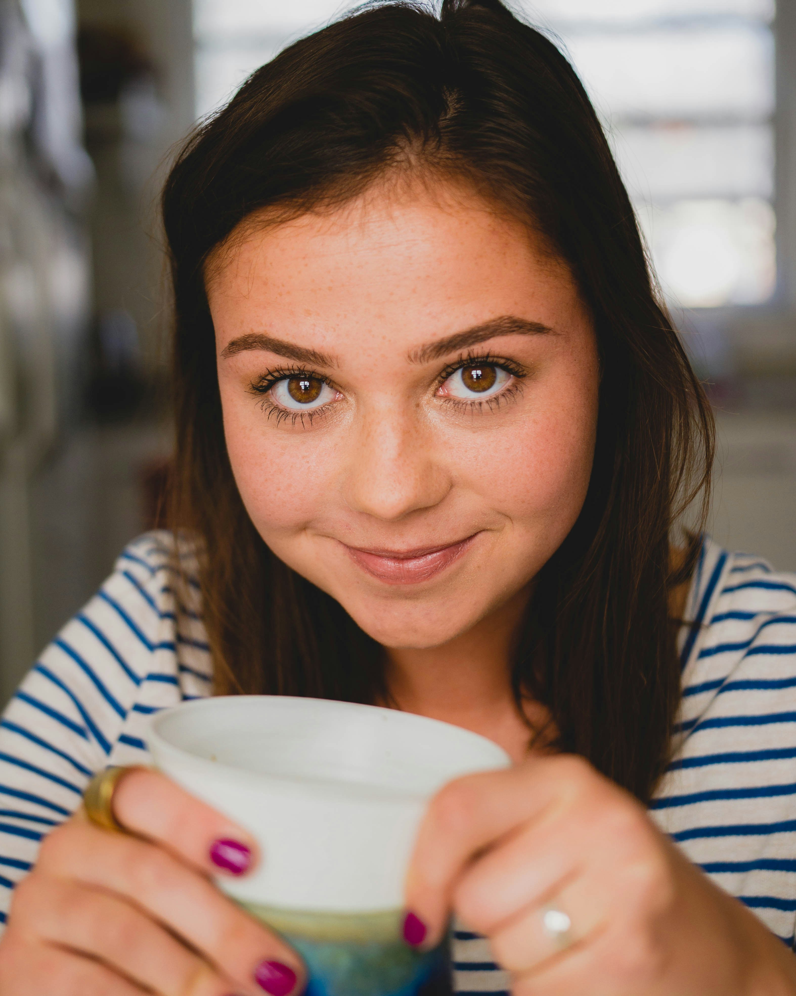 Una chica feliz con una taza en la mano | Fuente: Unsplash