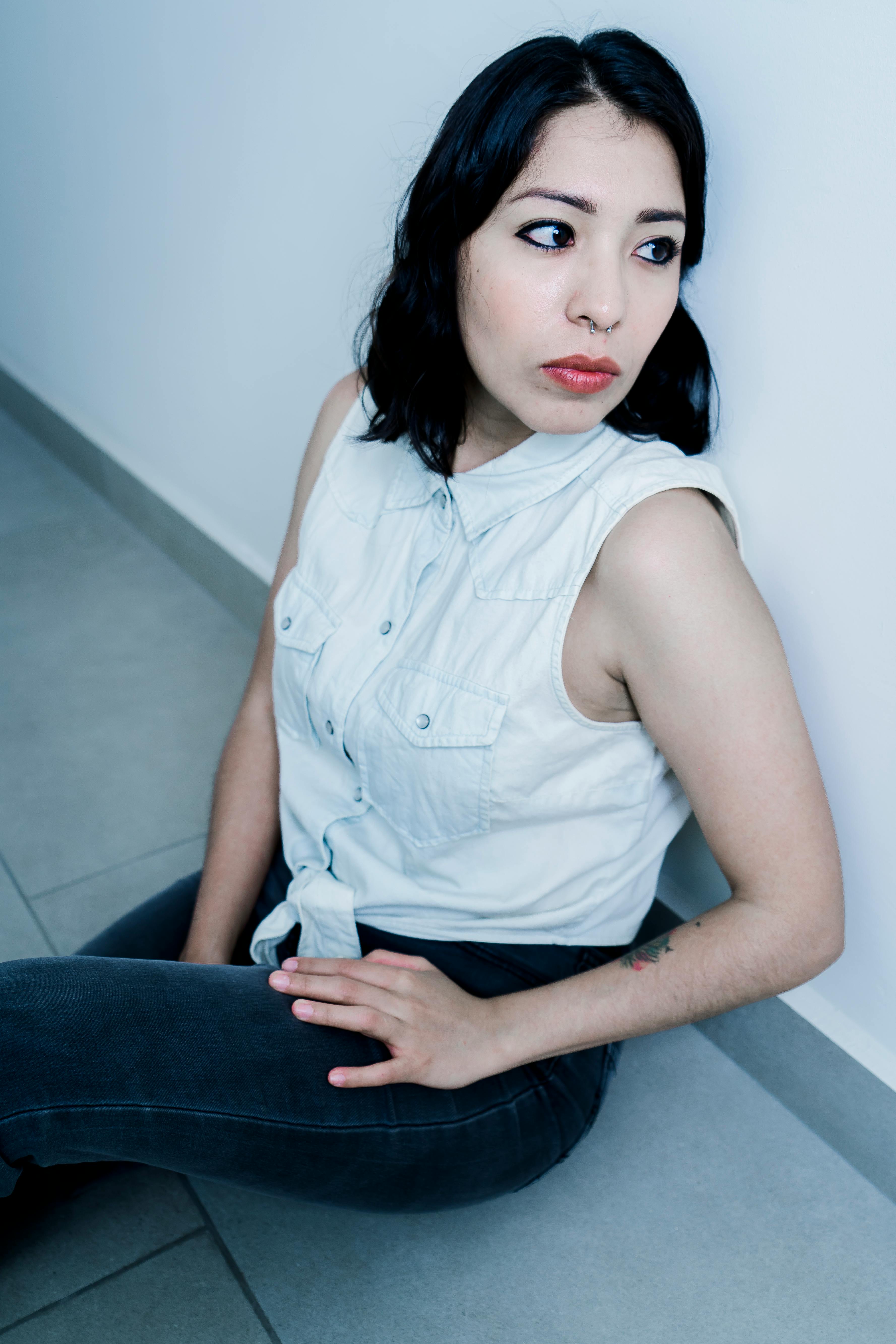 Una mujer sentada en el suelo mirando a un lado | Fuente: Pexels