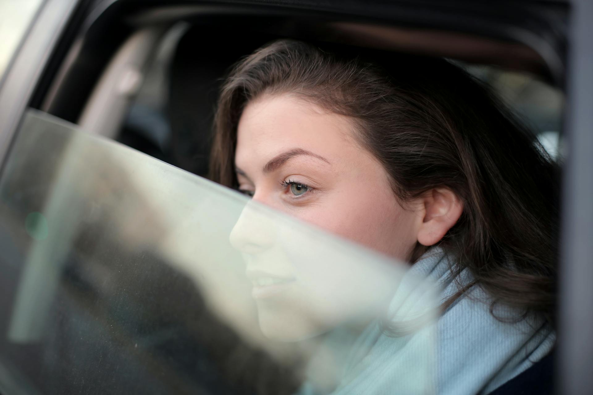 Una mujer mirando por la ventanilla del automóvil | Fuente: Pexels