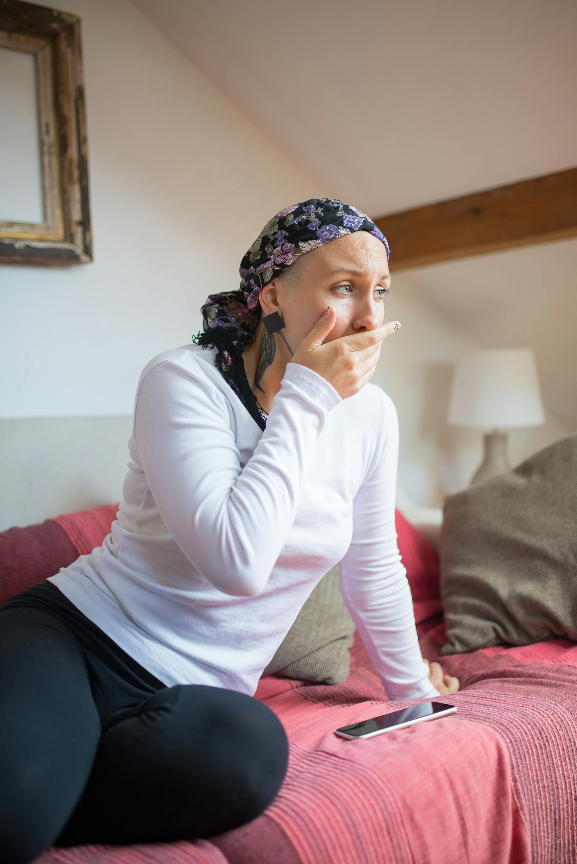 Una mujer con pañuelo en la cabeza sentada en un sofá | Fuente: Pexels