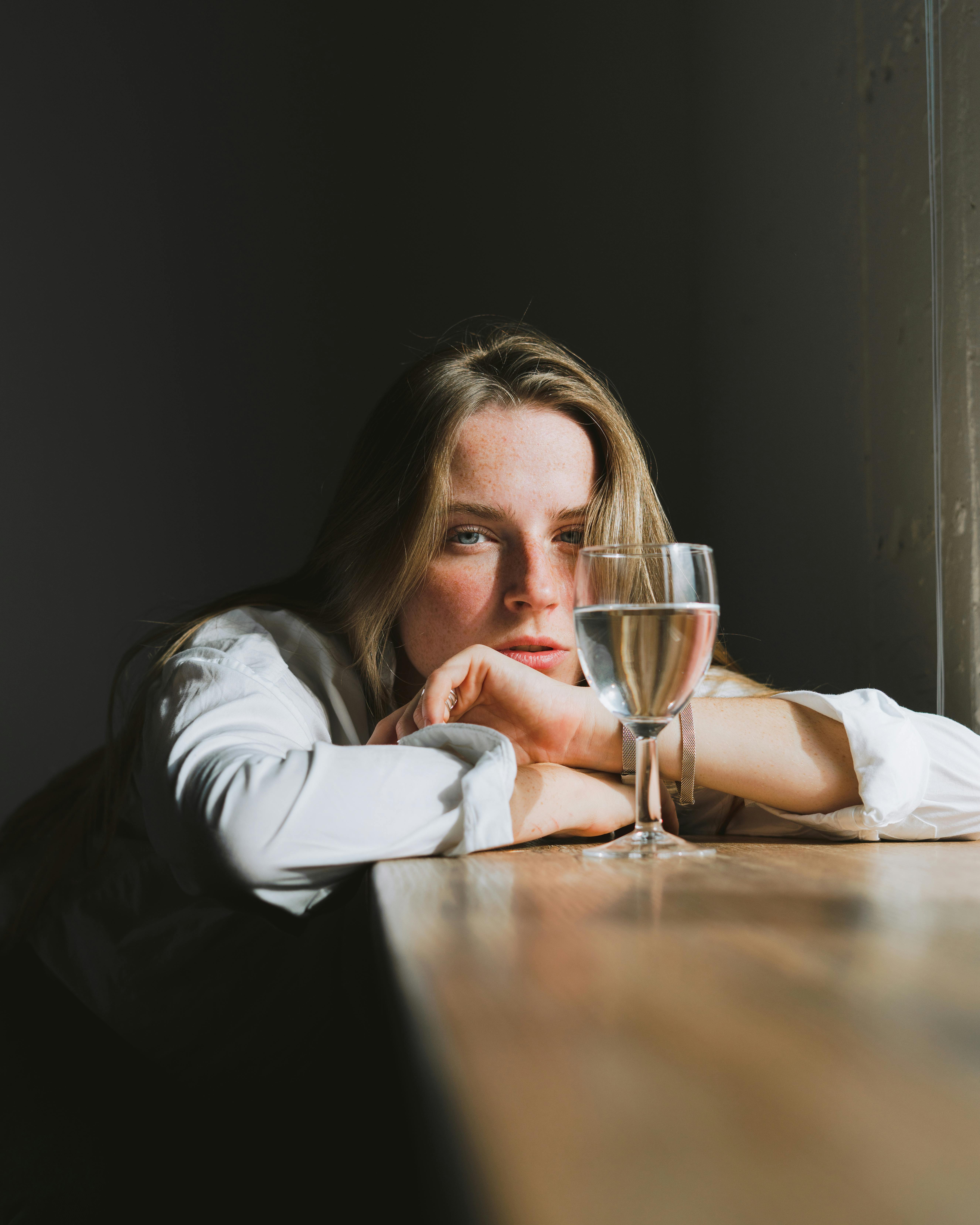 Una mujer triste bebiendo vino | Fuente: Pexels