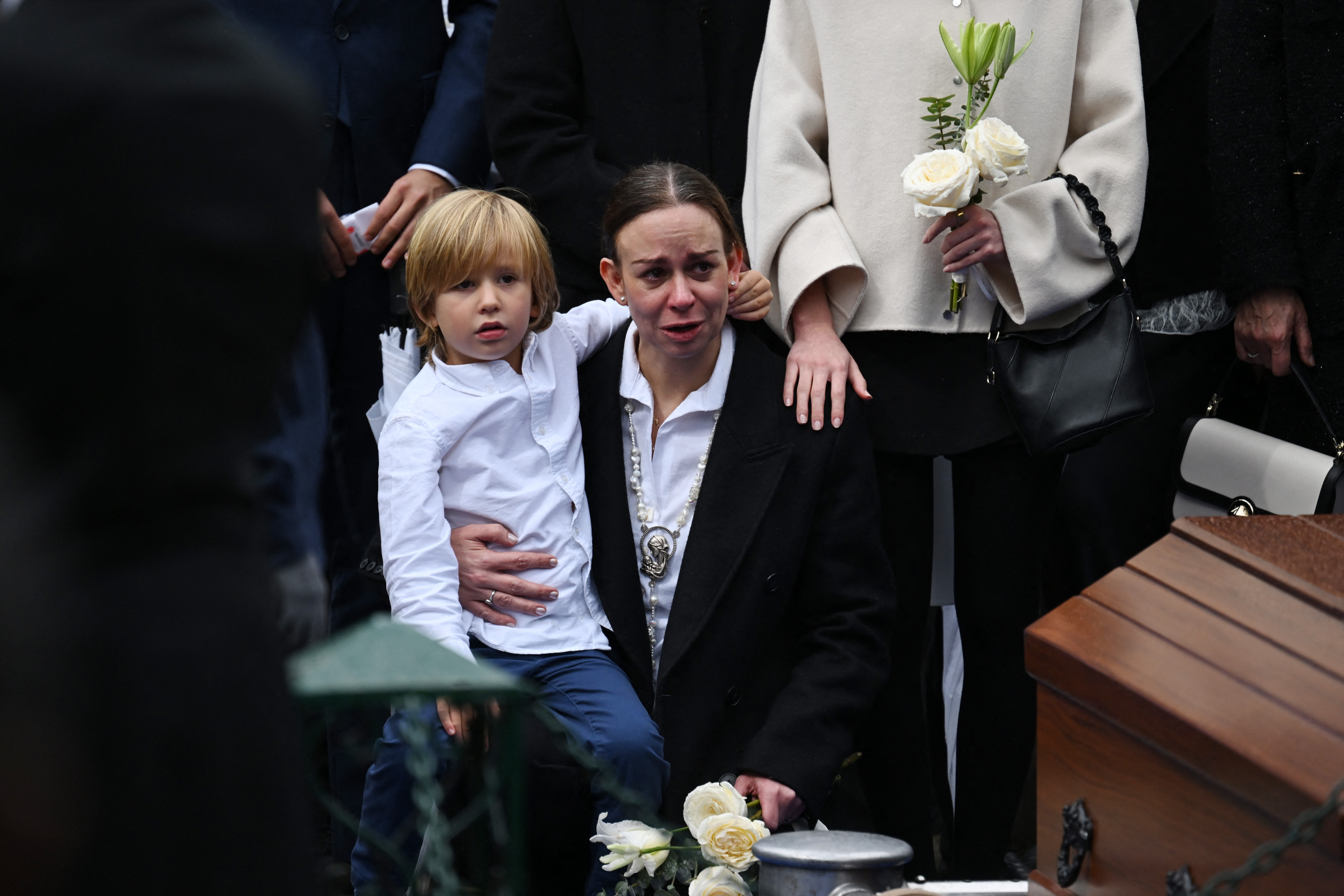María Claudia Tarazona, viuda del candidato presidencial y senador asesinado Miguel Uribe, llora durante su entierro con su hijo Alejandro en el Cementerio Central de Bogotá el 13 de agosto de 2025. | Fuente: Getty Images.
