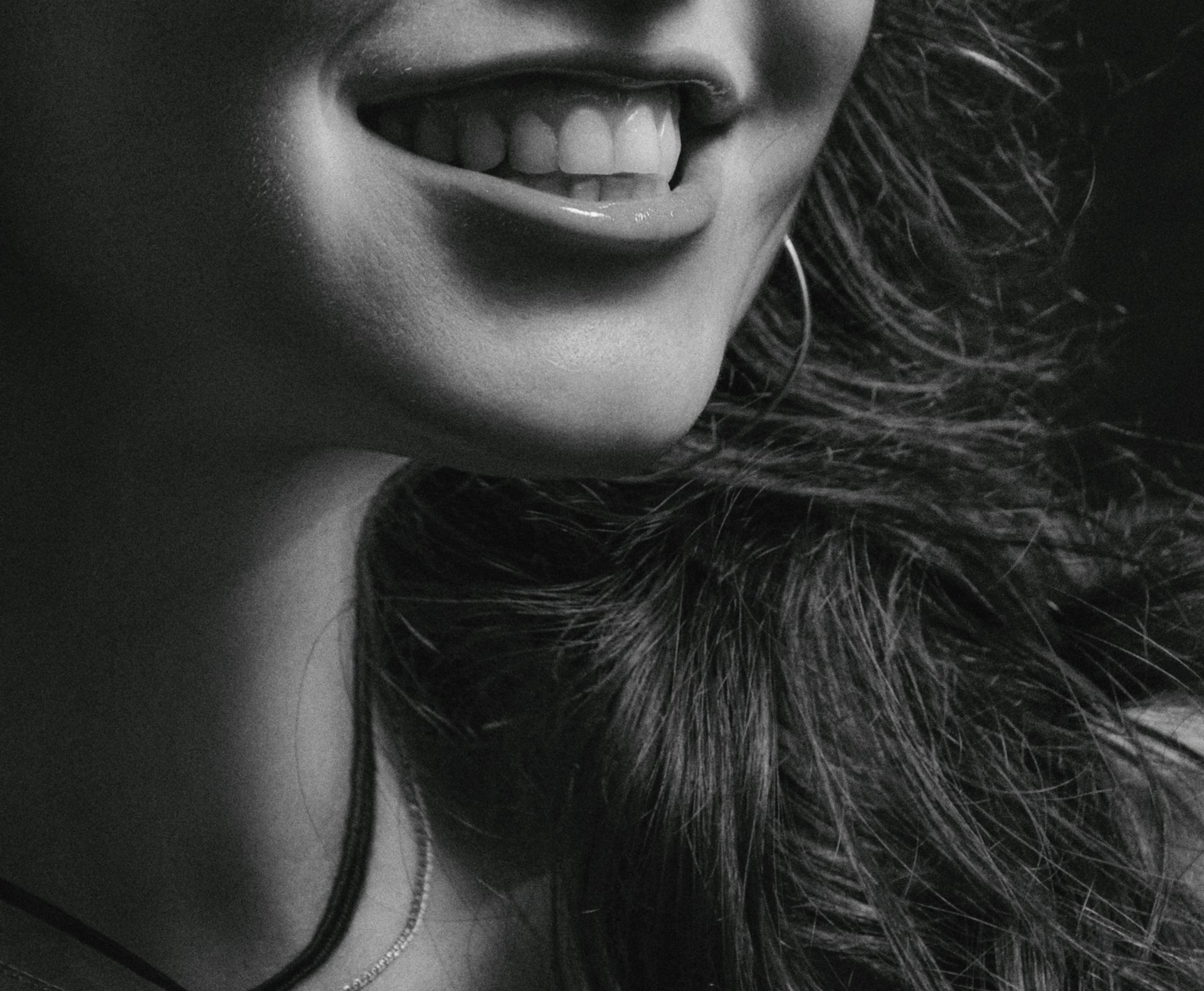 Toma en escala de grises de una mujer sonriendo | Fuente: Unsplash