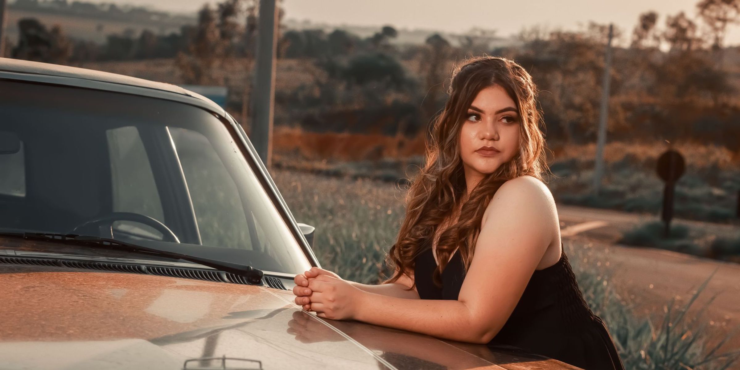 A woman leaning on a car | Source: Pexels