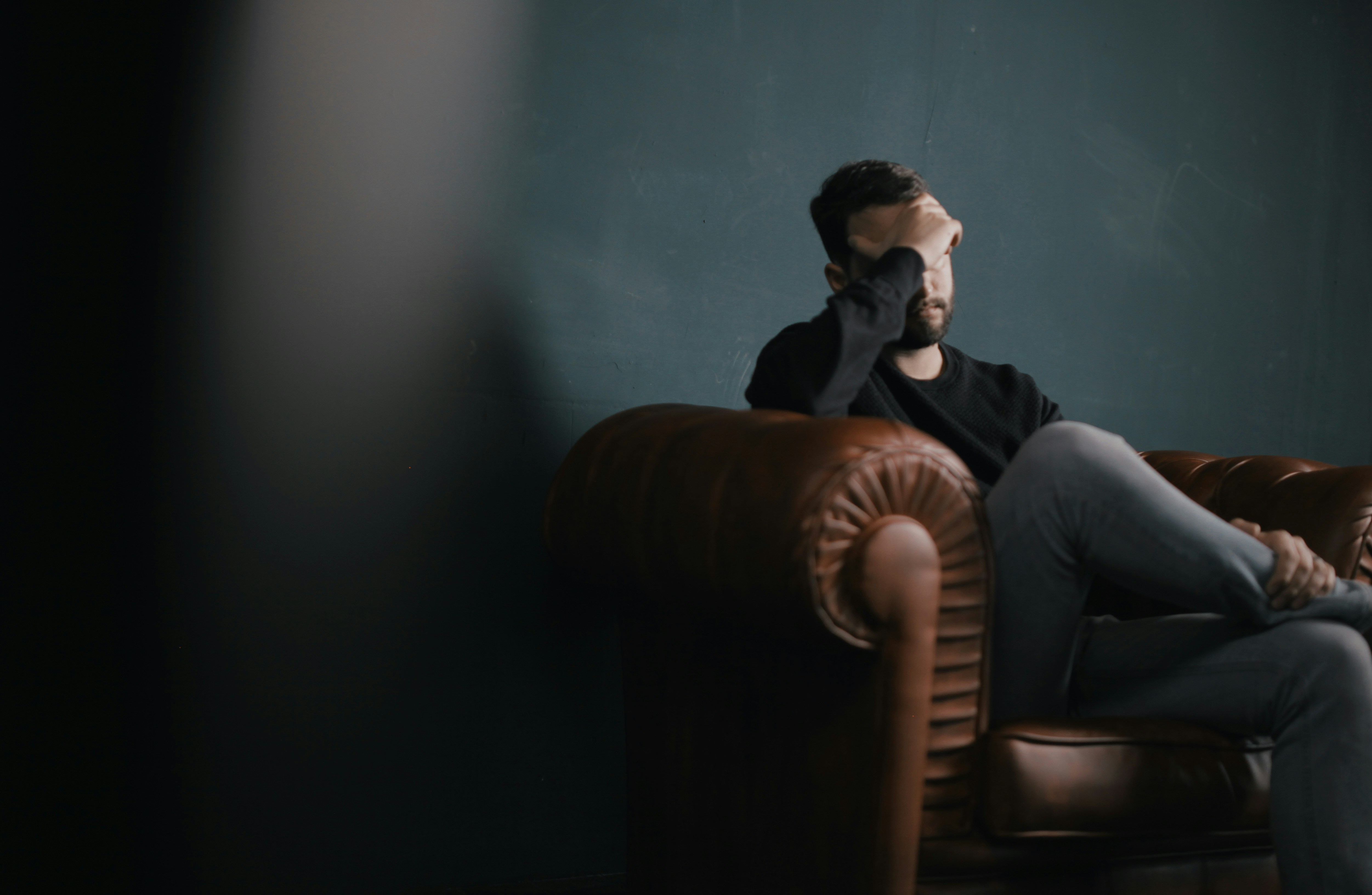 Un hombre estresado sentado en un sofá | Fuente: Unsplash