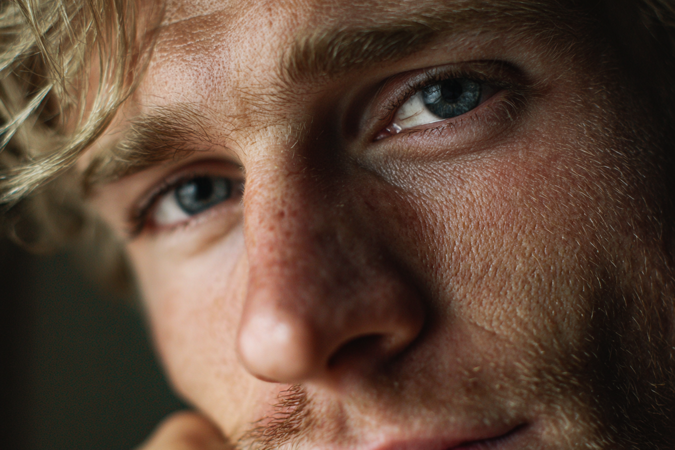 Un hombre con una mirada emocionada sonriendo débilmente a alguien | Fuente: Midjourney