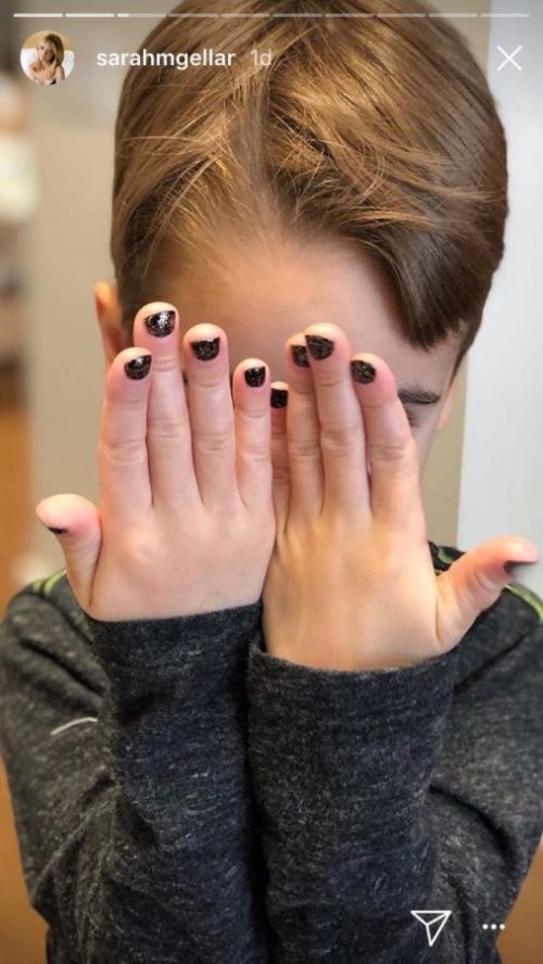 Rocky Prinze presumió de su manicura negra con purpurina en una foto que compartió su madre en las historias de Instagram, tapándose la cara en tono juguetón con ambas manos. Ese bonito momento de su infancia nos dejó entrever su lado más travieso. | Fuente: Historias de Instagram/@sarahmgellar