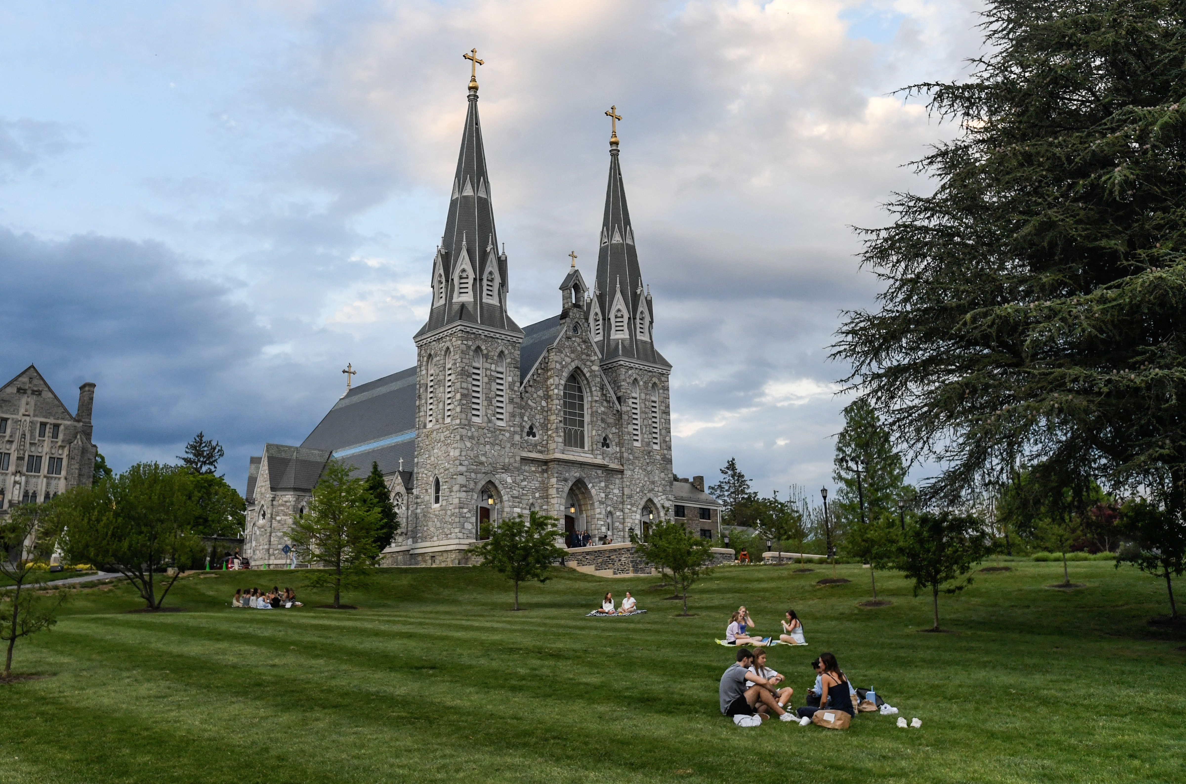 Estudiantes sentados en el césped fuera de la Iglesia de Santo Tomás de Villanueva en el campus de la Universidad de Villanueva en Pensilvania el 8 de mayo de 2025 | Fuente: Getty Images