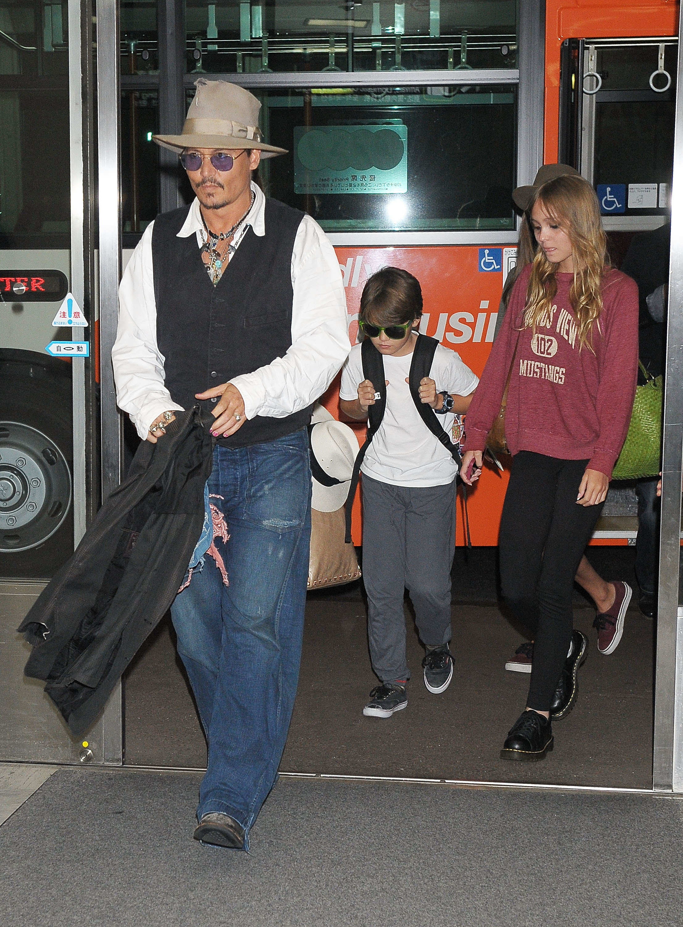 Johnny Depp camina por el Aeropuerto Internacional de Narita en Japón con sus hijos, Jack Depp y Lily-Rose Depp, el 16 de julio de 2013 | Fuente: Getty Images