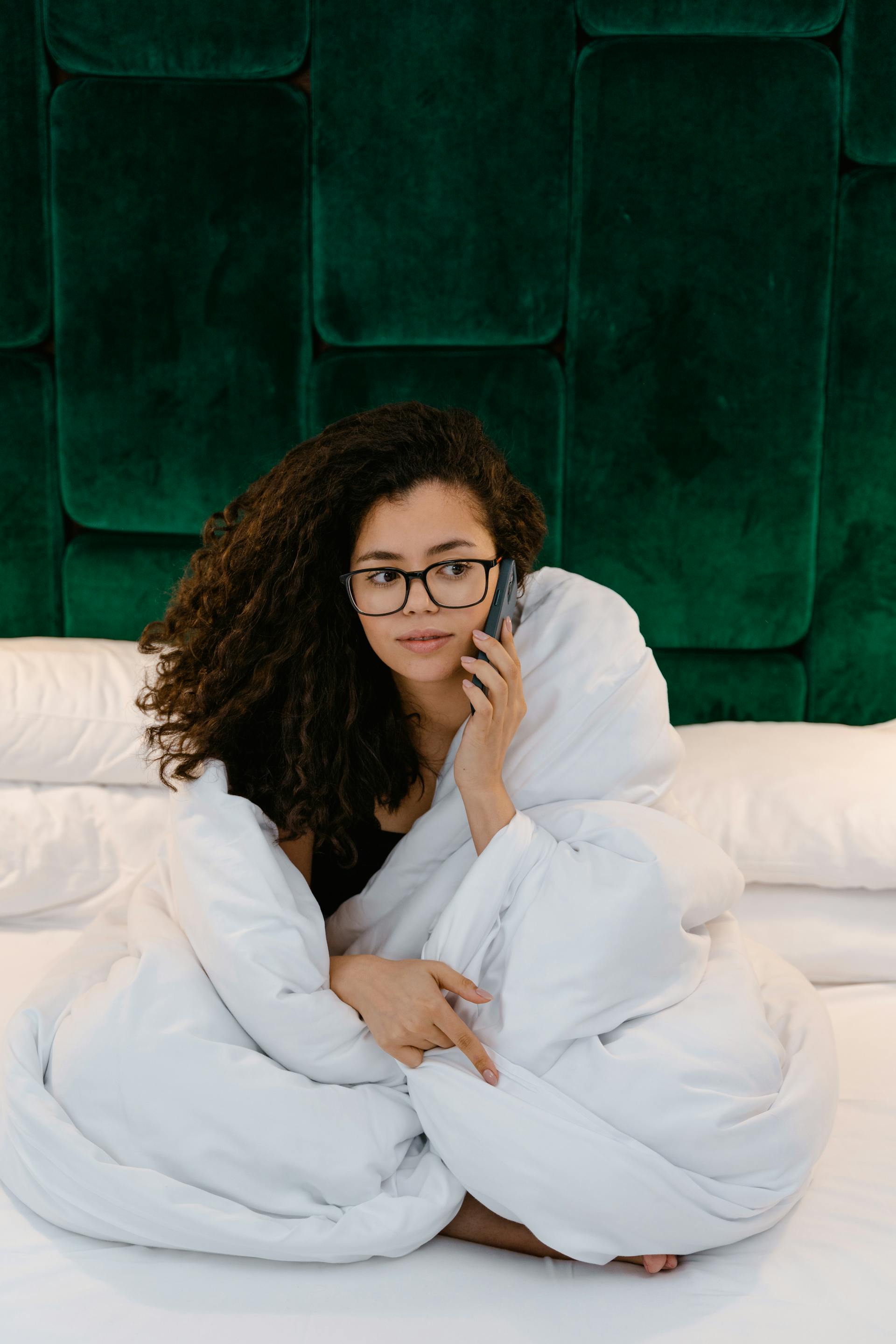 Una mujer hablando por teléfono en la cama | Fuente: Pexels