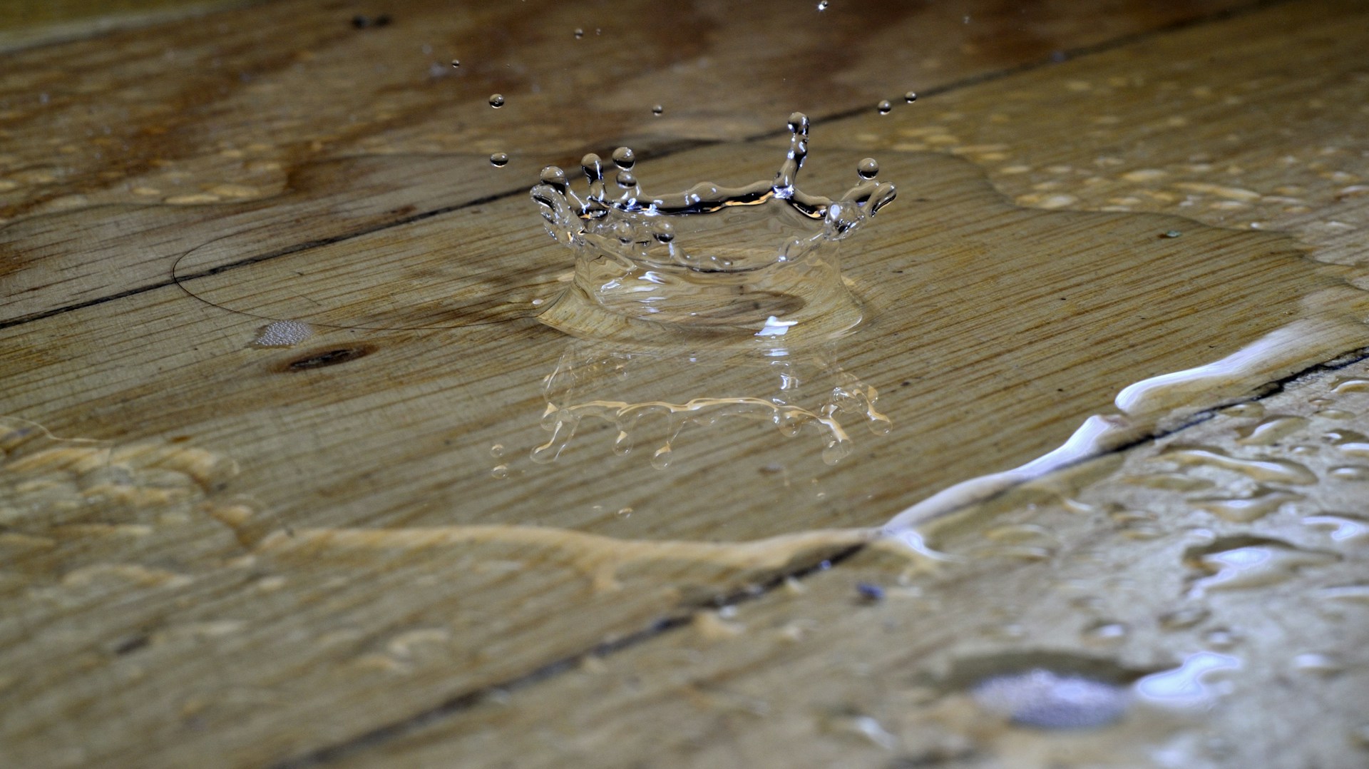 Un charco de agua en un suelo de madera | Fuente: Unsplash