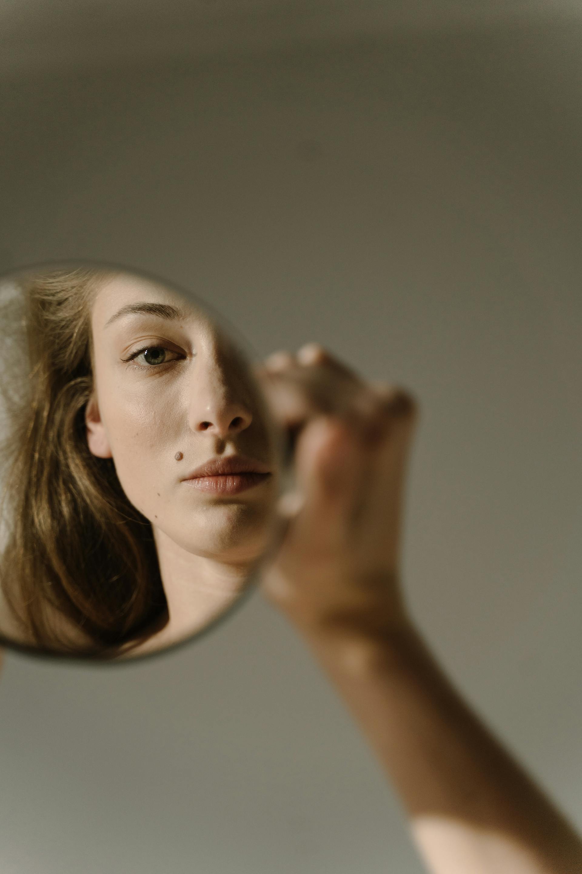 Una mujer mirando su reflejo en el espejo | Fuente: Pexels