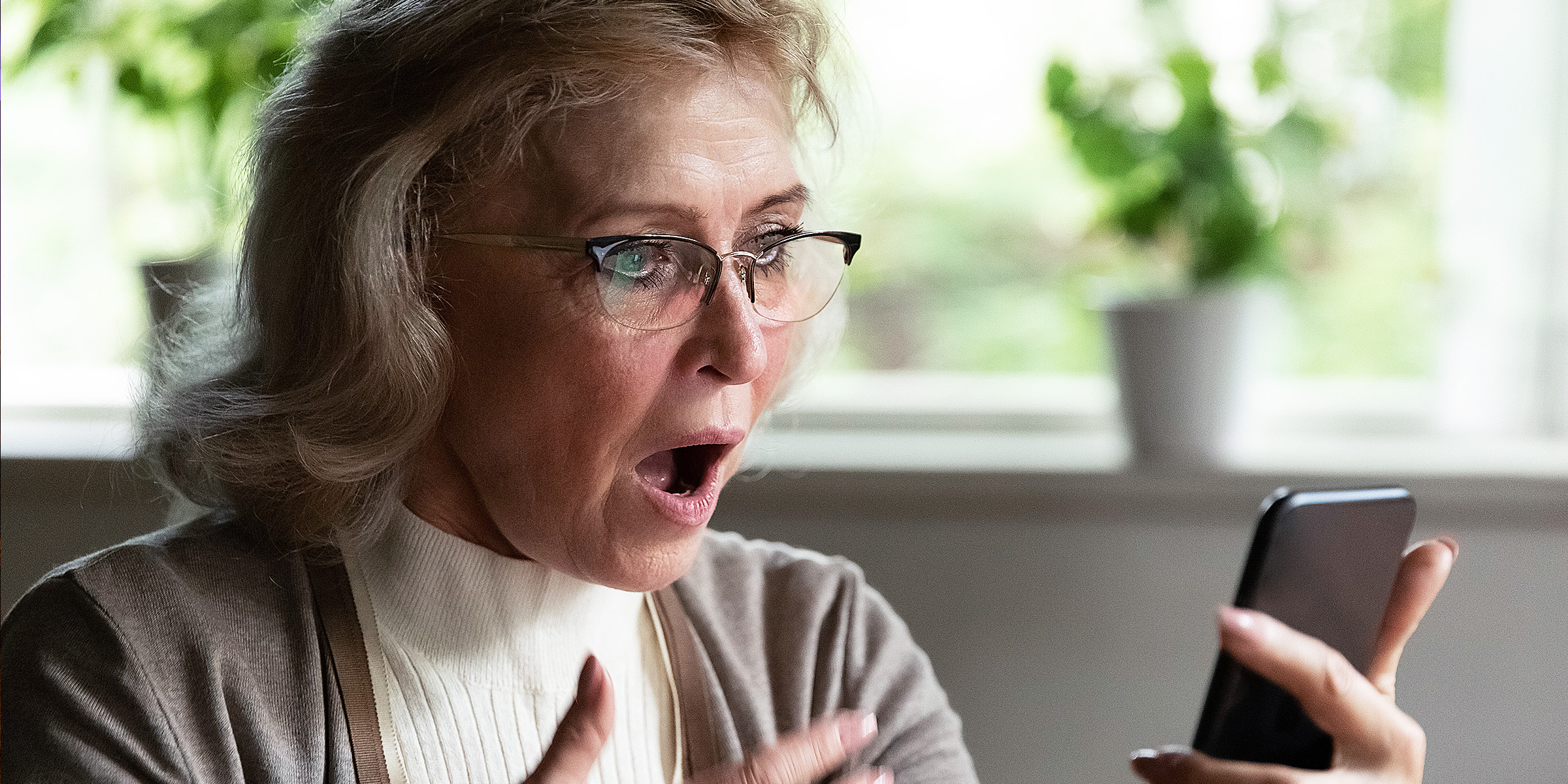 Una mujer mira atónita su teléfono | Fuente: Shutterstock