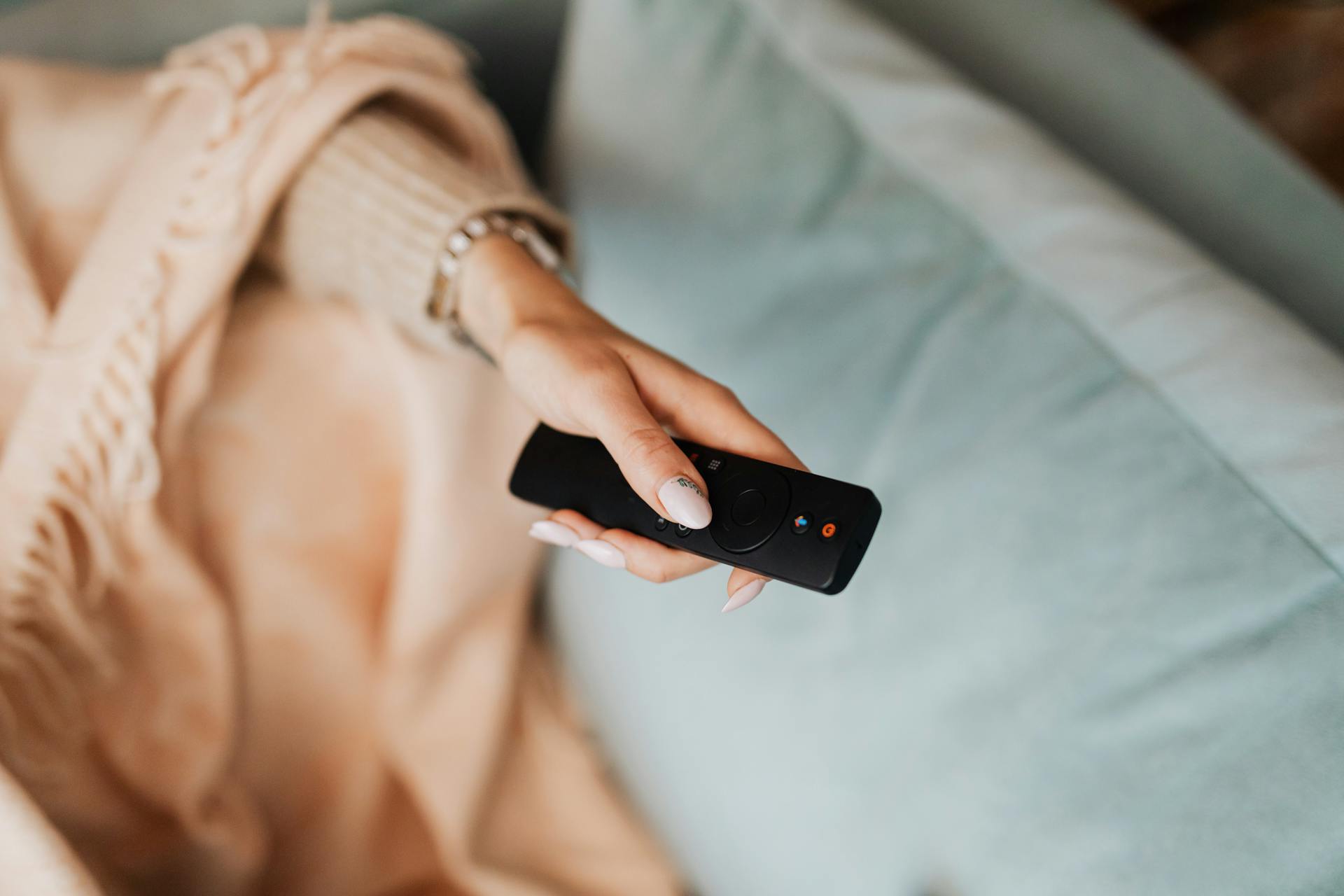 Primer plano de una mujer sujetando un mando a distancia | Fuente: Pexels