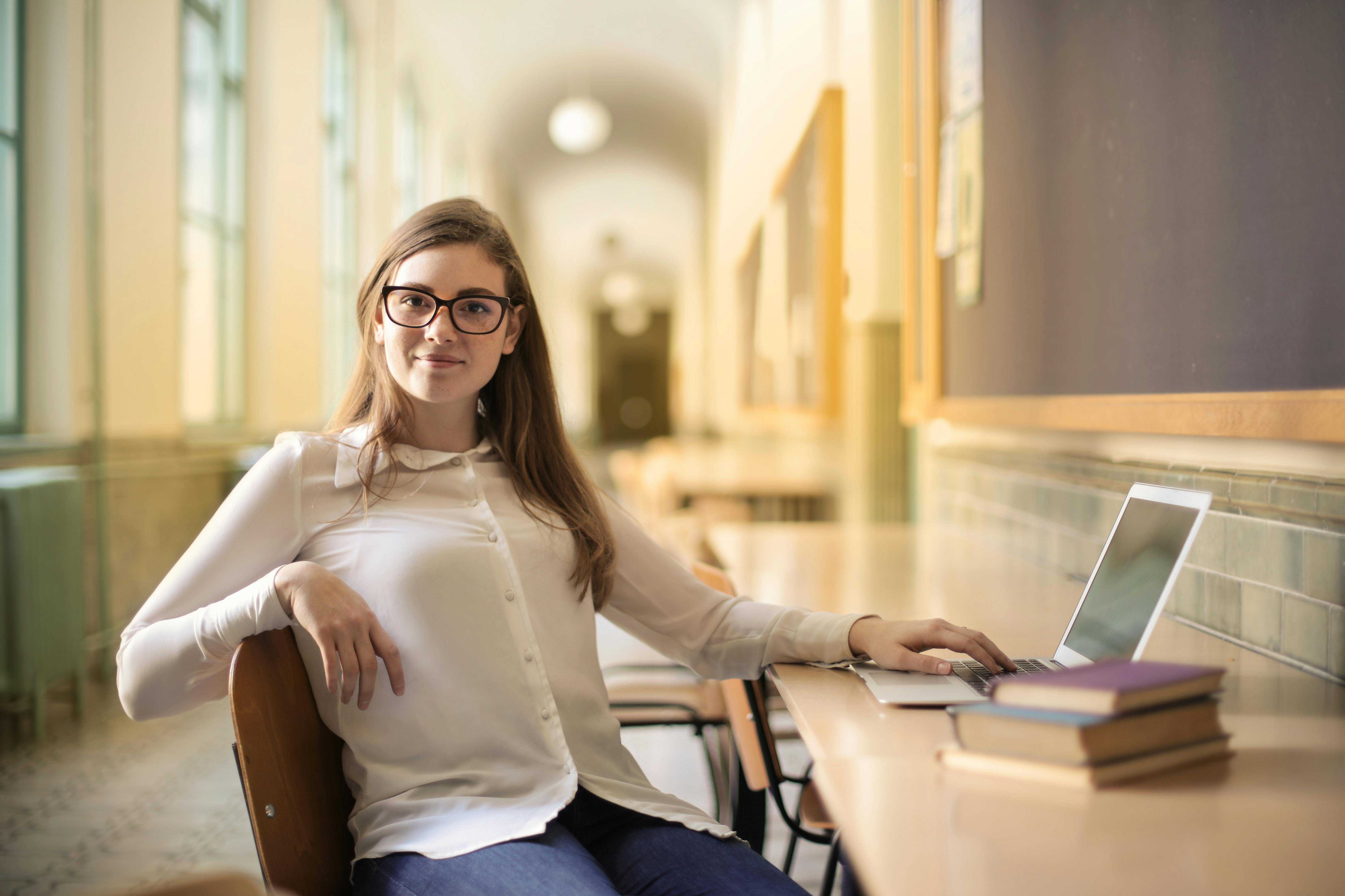 Mujer sonriendo sentada en una silla | Fuente: Pexels