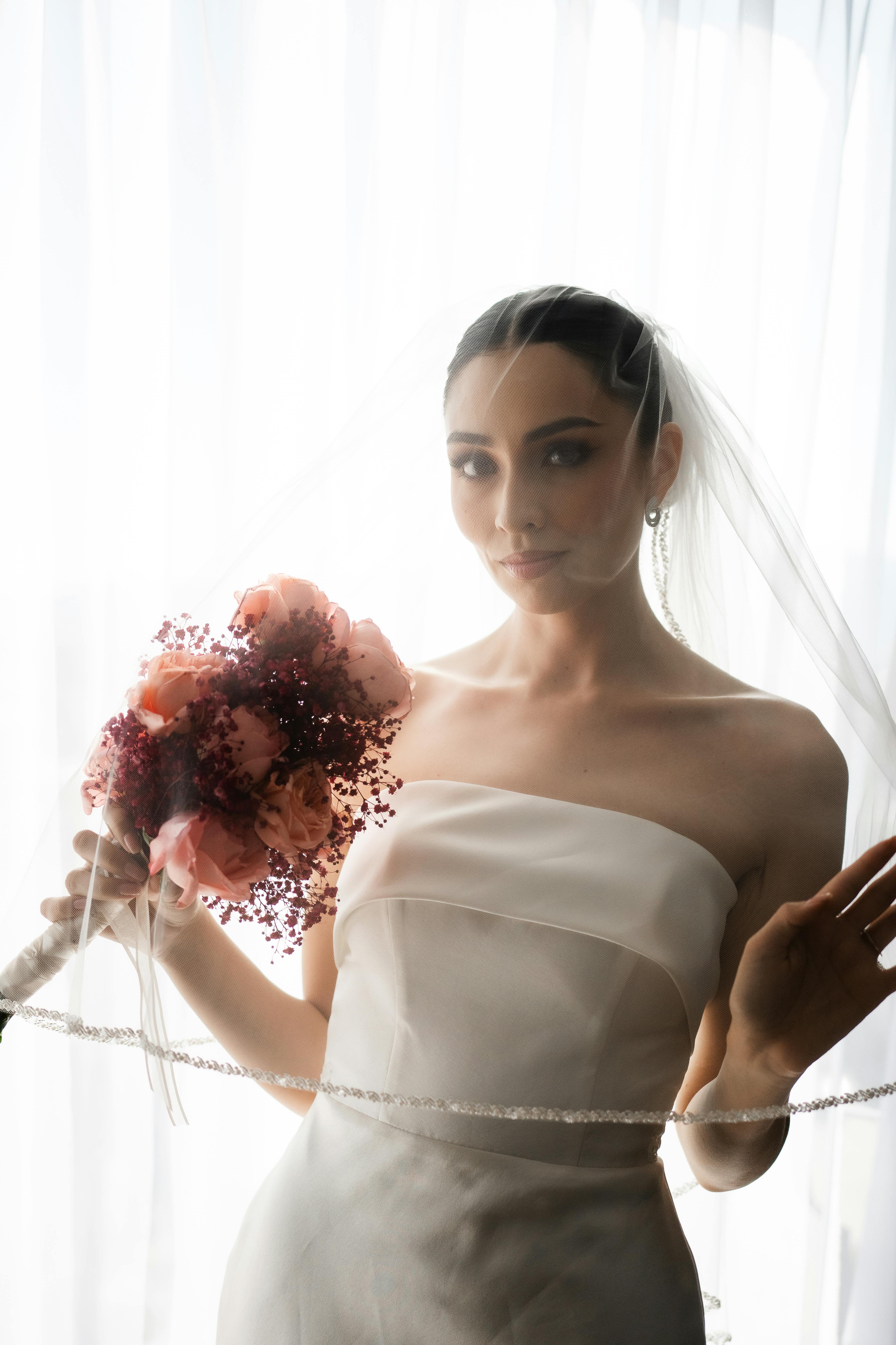 Una hermosa novia sosteniendo un ramo | Fuente: Pexels