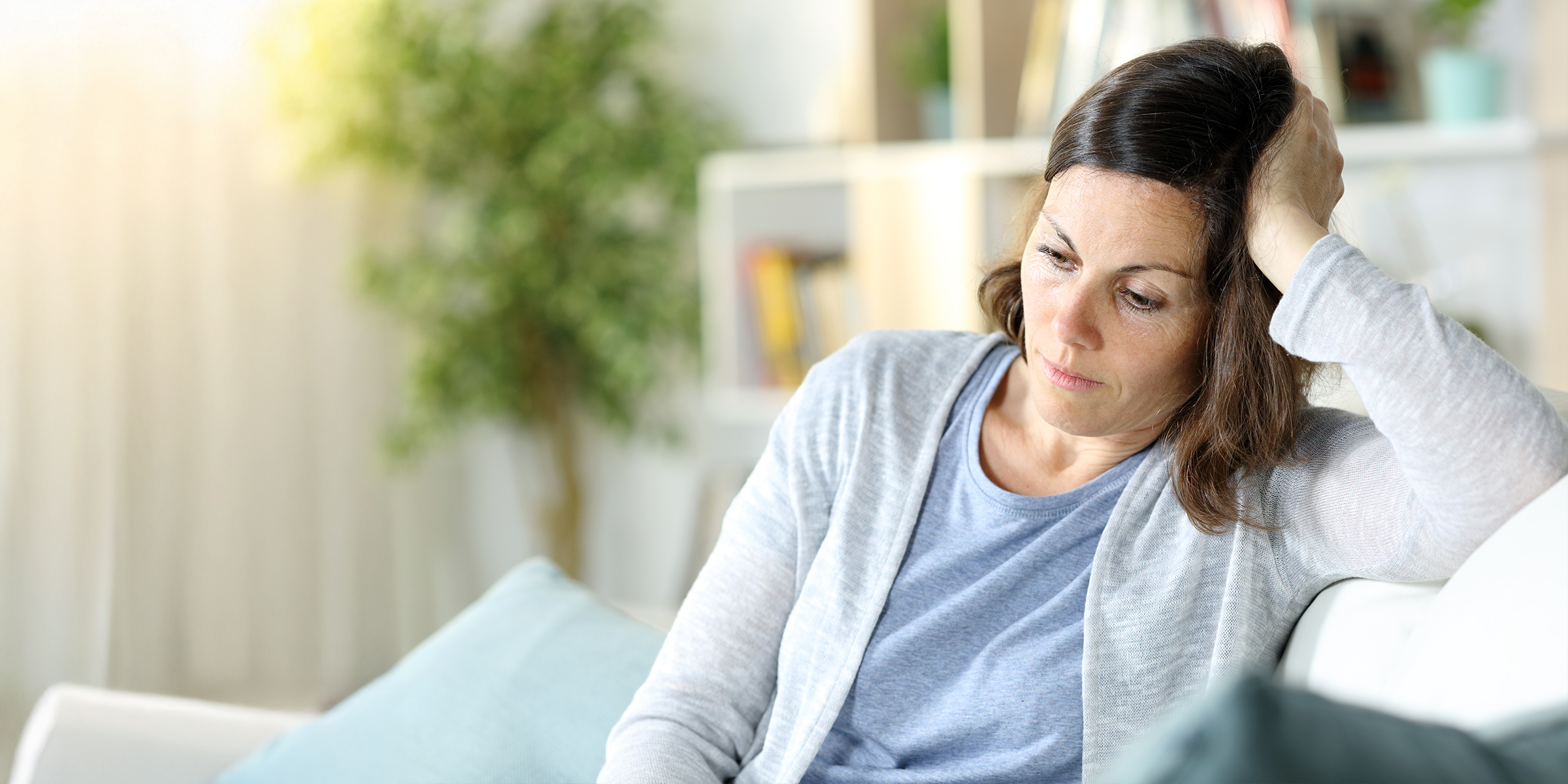 Una mujer triste y pensativa en un salón | Fuente: Shutterstock