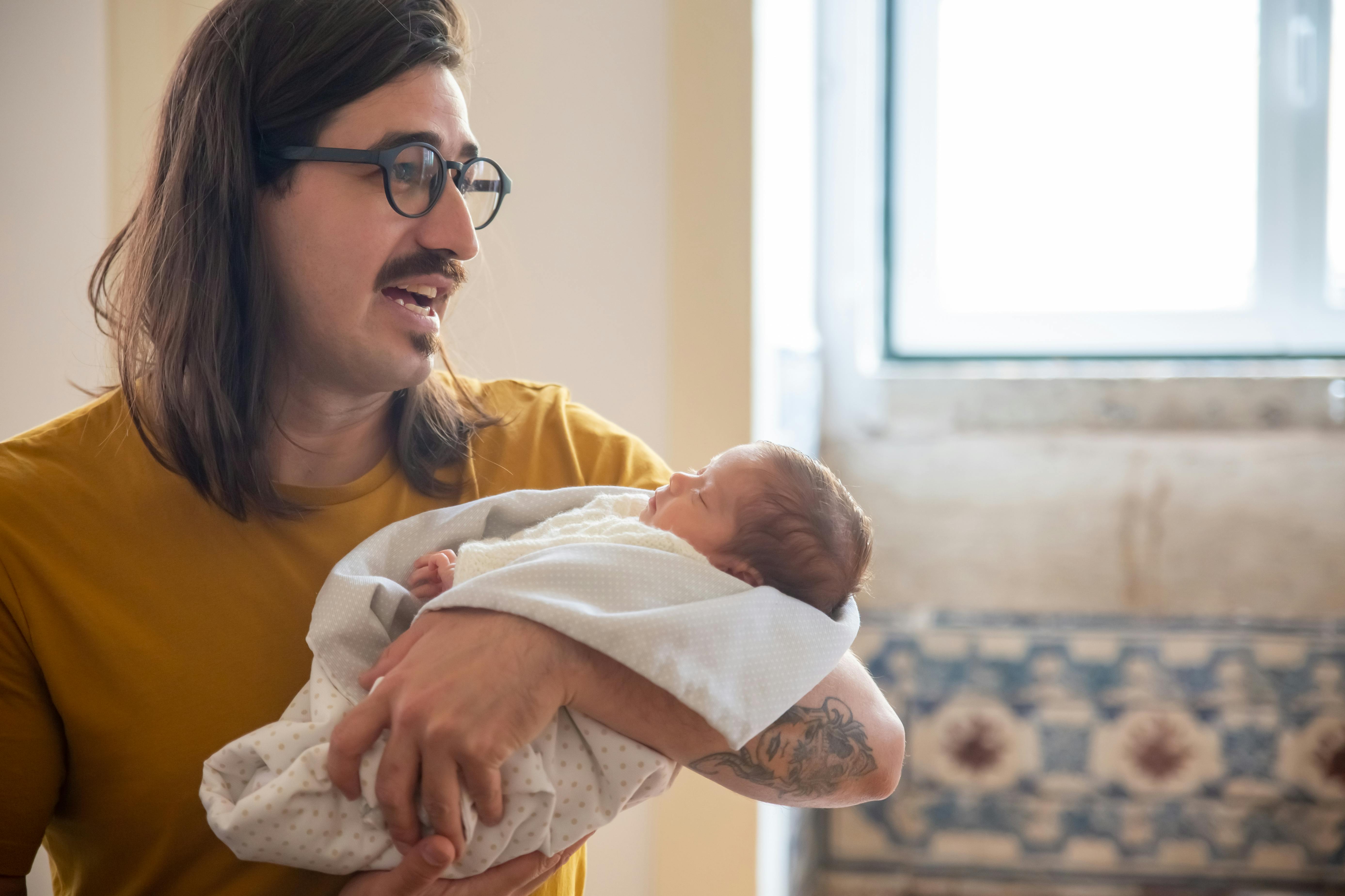 Un hombre acuna a un bebé | Fuente: Pexels