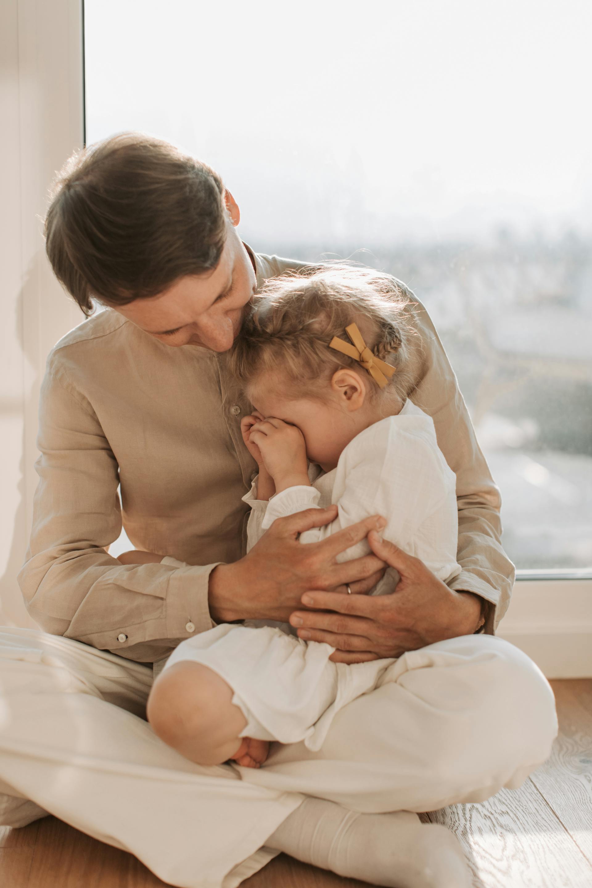 Un papá consolando a su pequeña hija triste | Fuente: Pexels