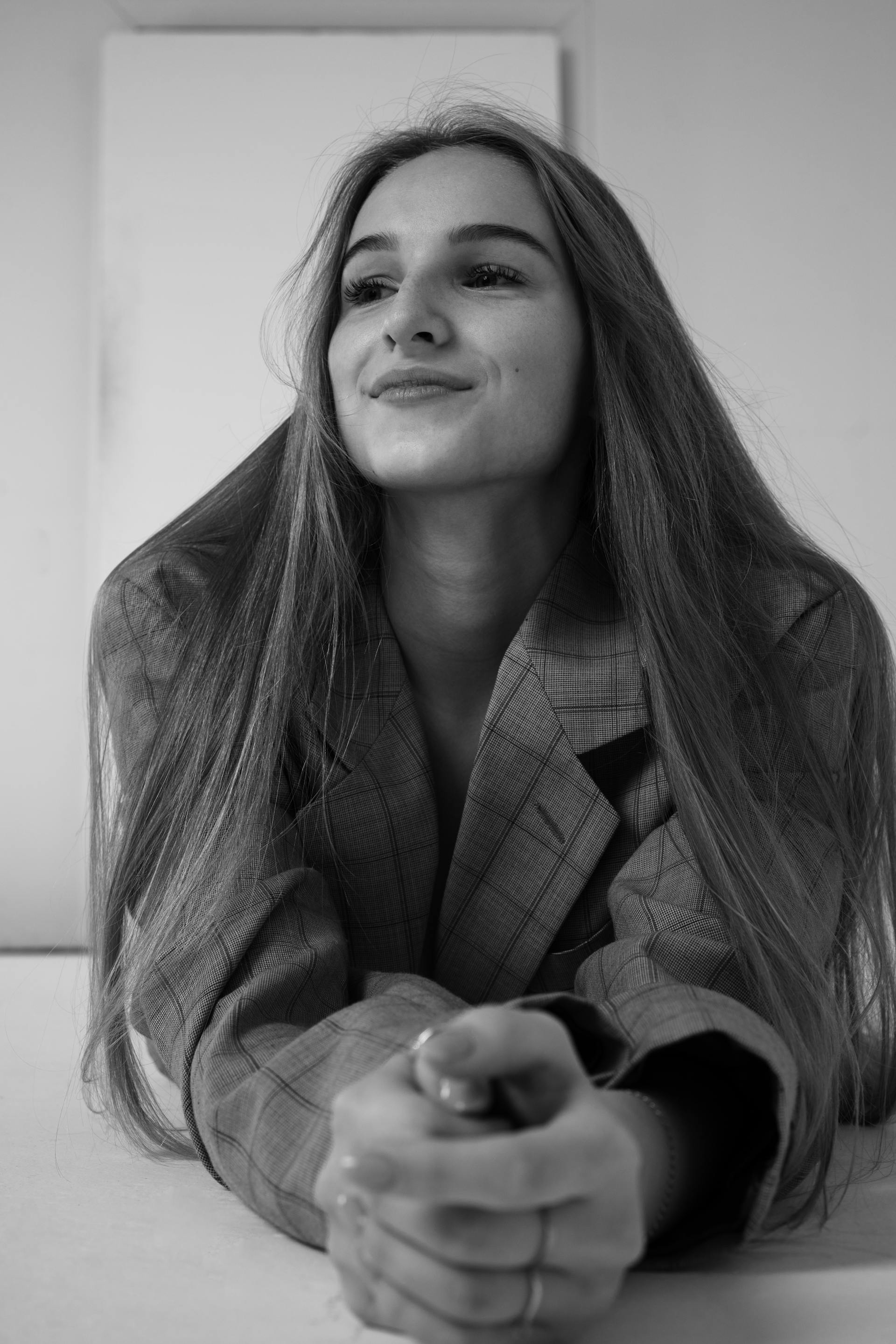 Foto en escala de grises de una joven sonriendo | Fuente: Pexels