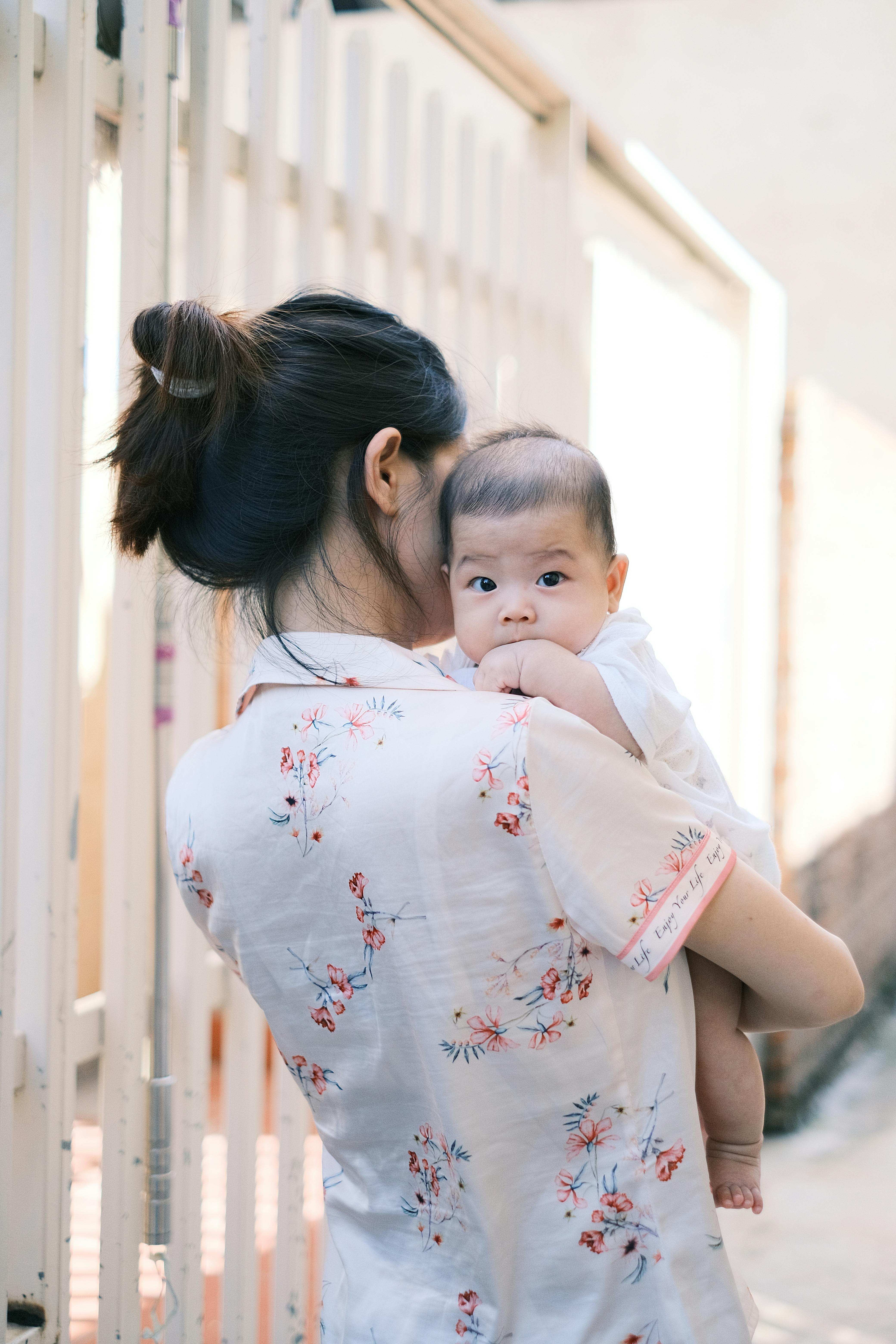Mujer con un bebé en brazos | Fuente: Pexels
