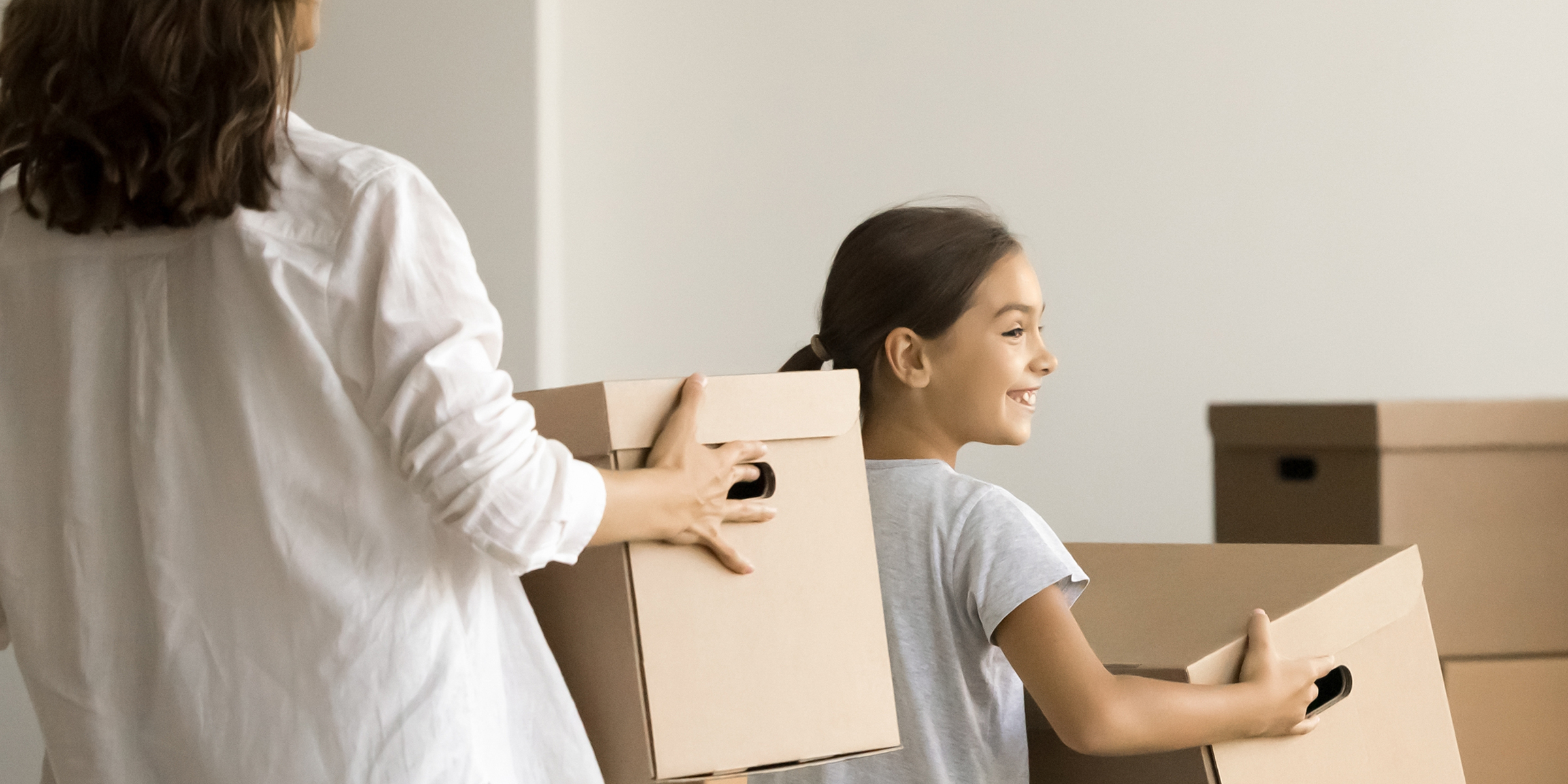 Una mujer y su hija sujetando cajas | Fuente: Shutterstock