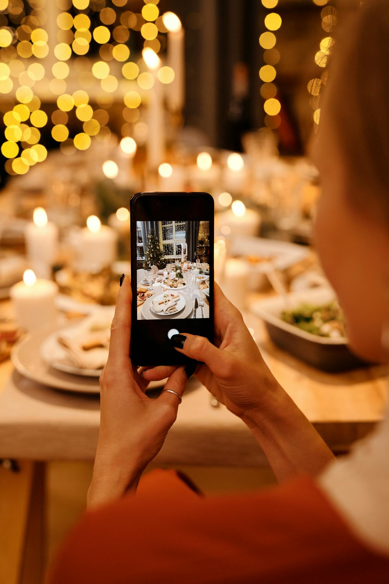Una mujer haciendo una foto de la comida en la mesa | Fuente: Pexels
