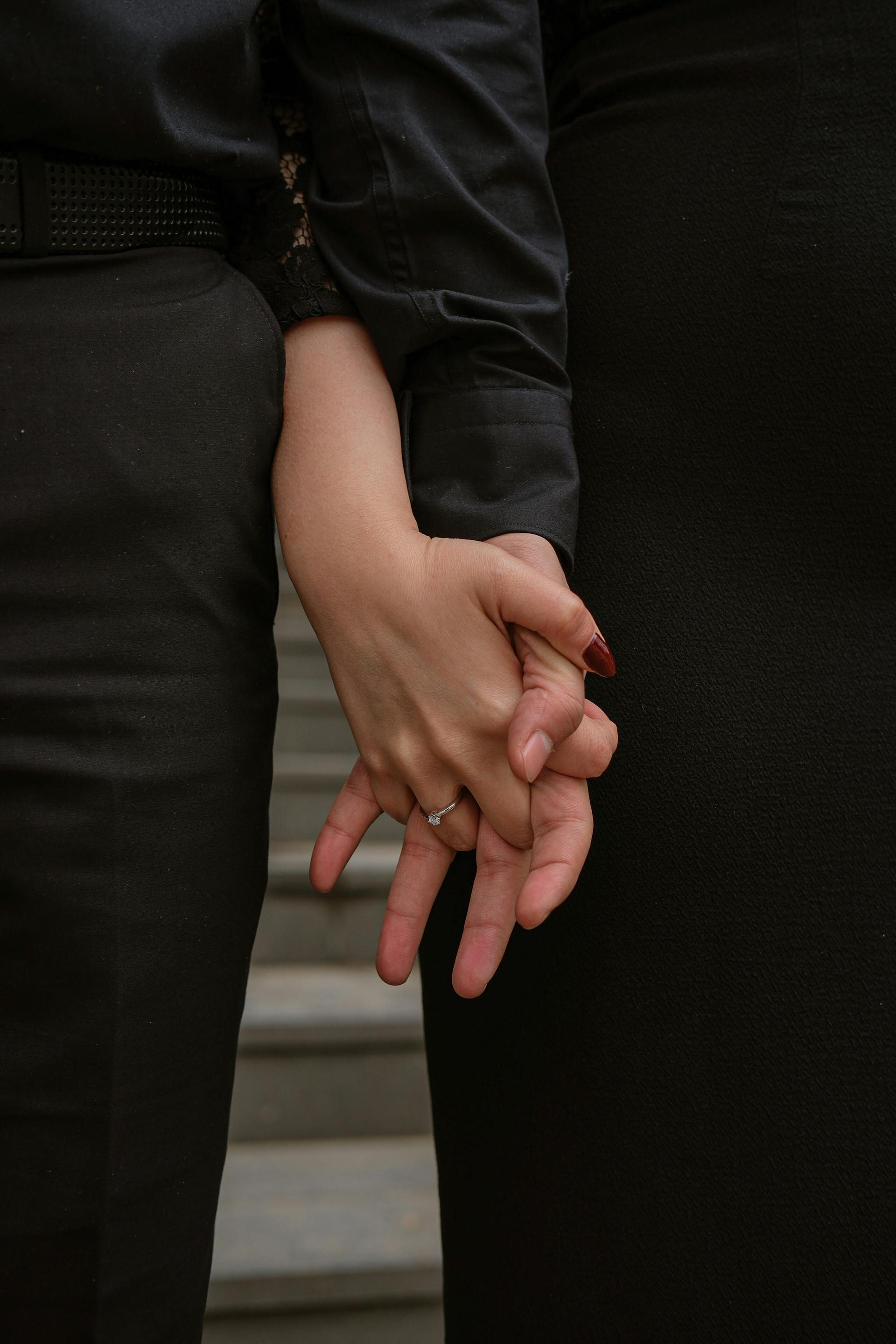 Una pareja de la mano en las escaleras de un edificio | Fuente: Pexels