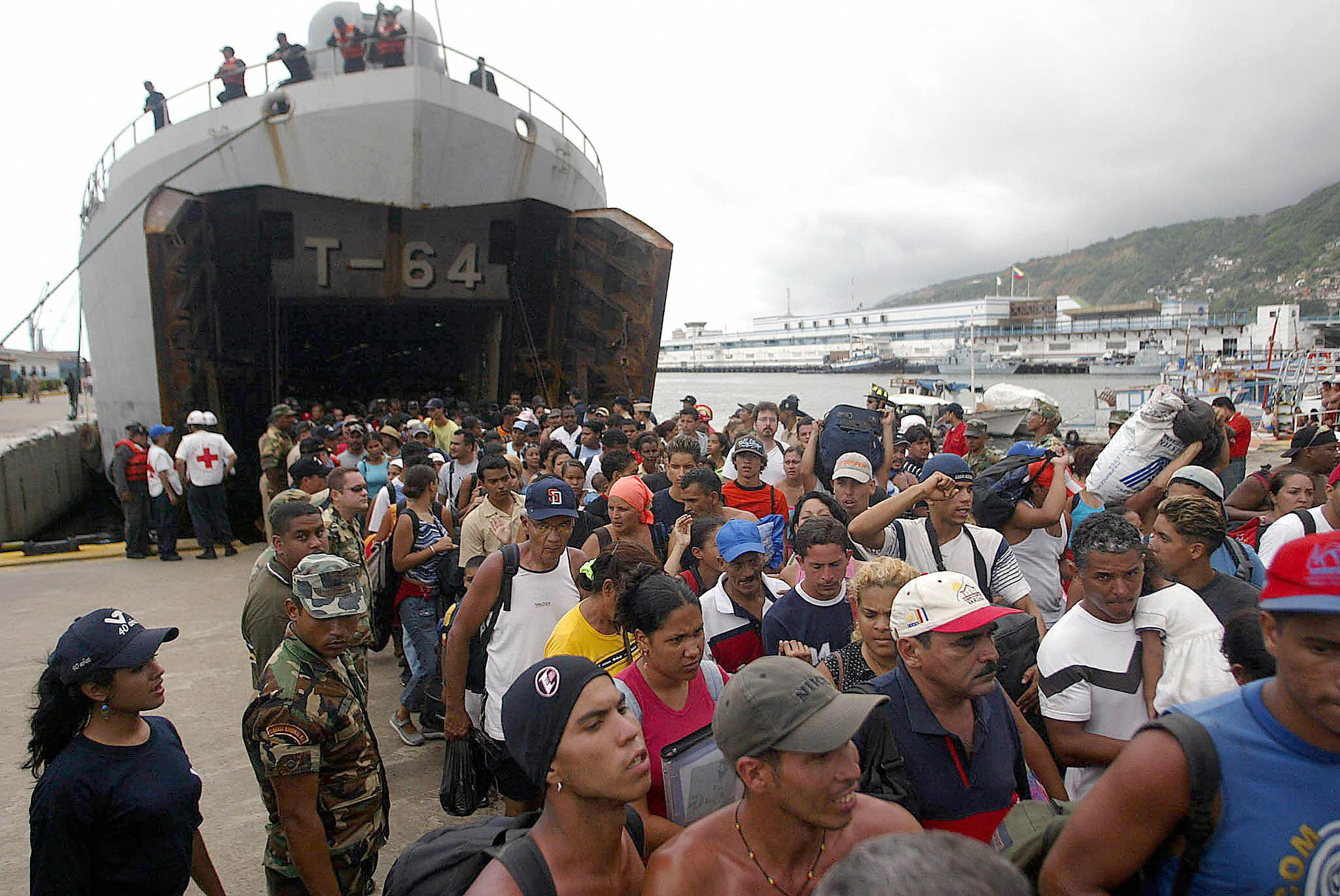 Personas desembarcan de un barco de las Fuerzas Armadas de Venezuela en el puerto de La Guaira tras ser evacuadas de las playas del estado Vargas. | Fuente: Getty Images.