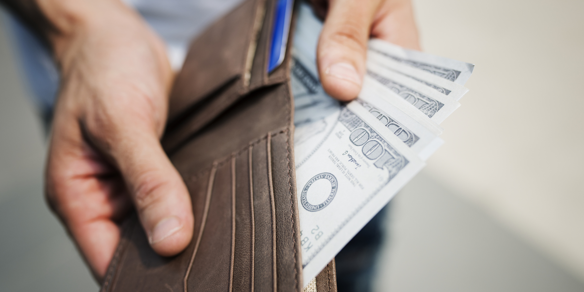 Una persona metiendo dinero en su cartera | Fuente: Freepik