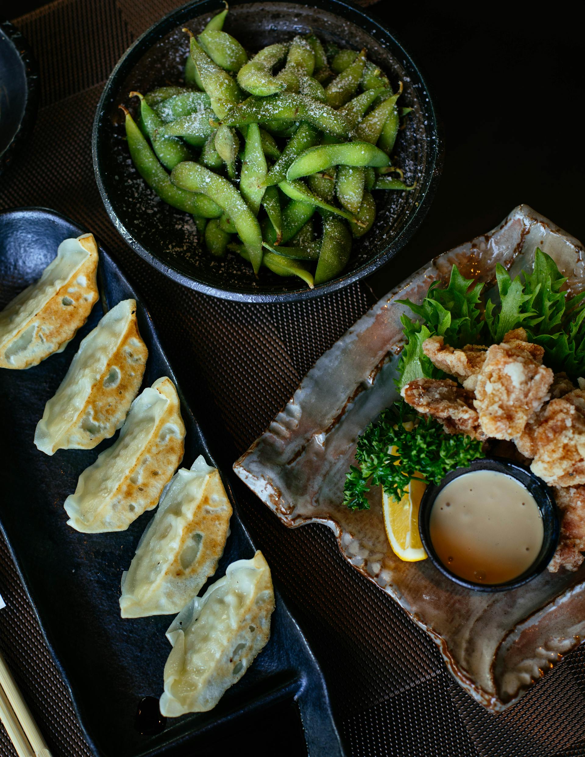 Soja, dumplings cocidos y pollo servidos en una mesa | Fuente: Pexels