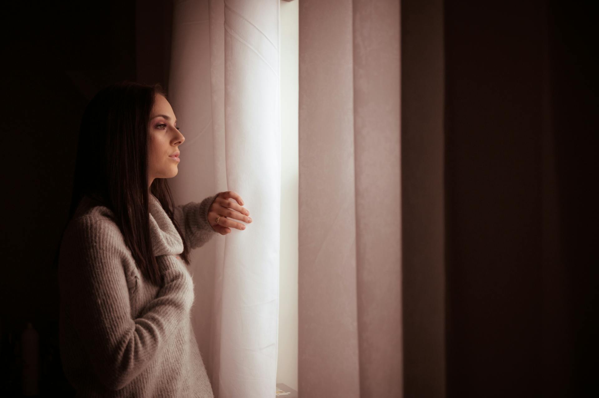 Una mujer mirando pensativa por una ventana | Fuente: Pexels