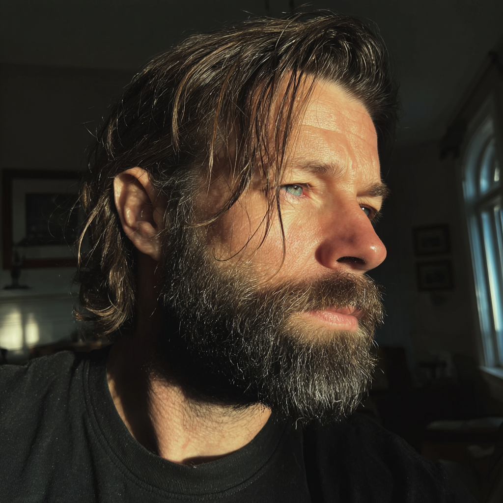 Un hombre pensativo con una camiseta negra | Fuente: Midjourney