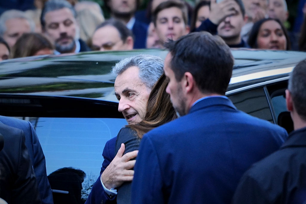El expresidente francés Nicolas Sarkozy abraza a su esposa Carla Bruni Sarkozy antes de subir al coche que le llevará a la prisión de la Santé, donde cumplirá una condena de cinco años de prisión, en París, el 21 de octubre de 2025. | Fuente: Getty Images