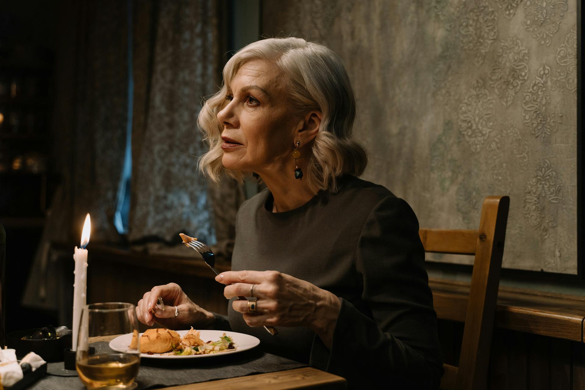 Una mujer mayor parece asustada mientras cena | Fuente: Pexels