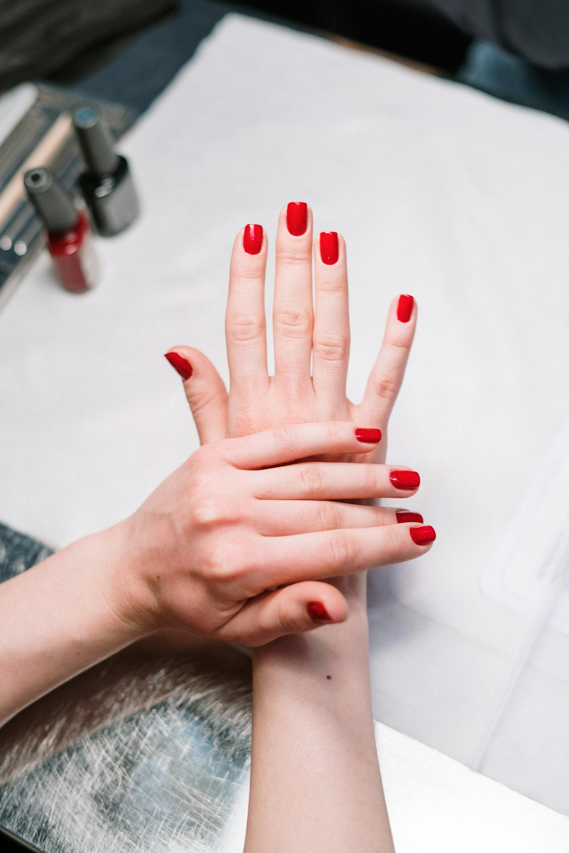 Una mujer con las uñas pintadas de rojo | Fuente: Pexels