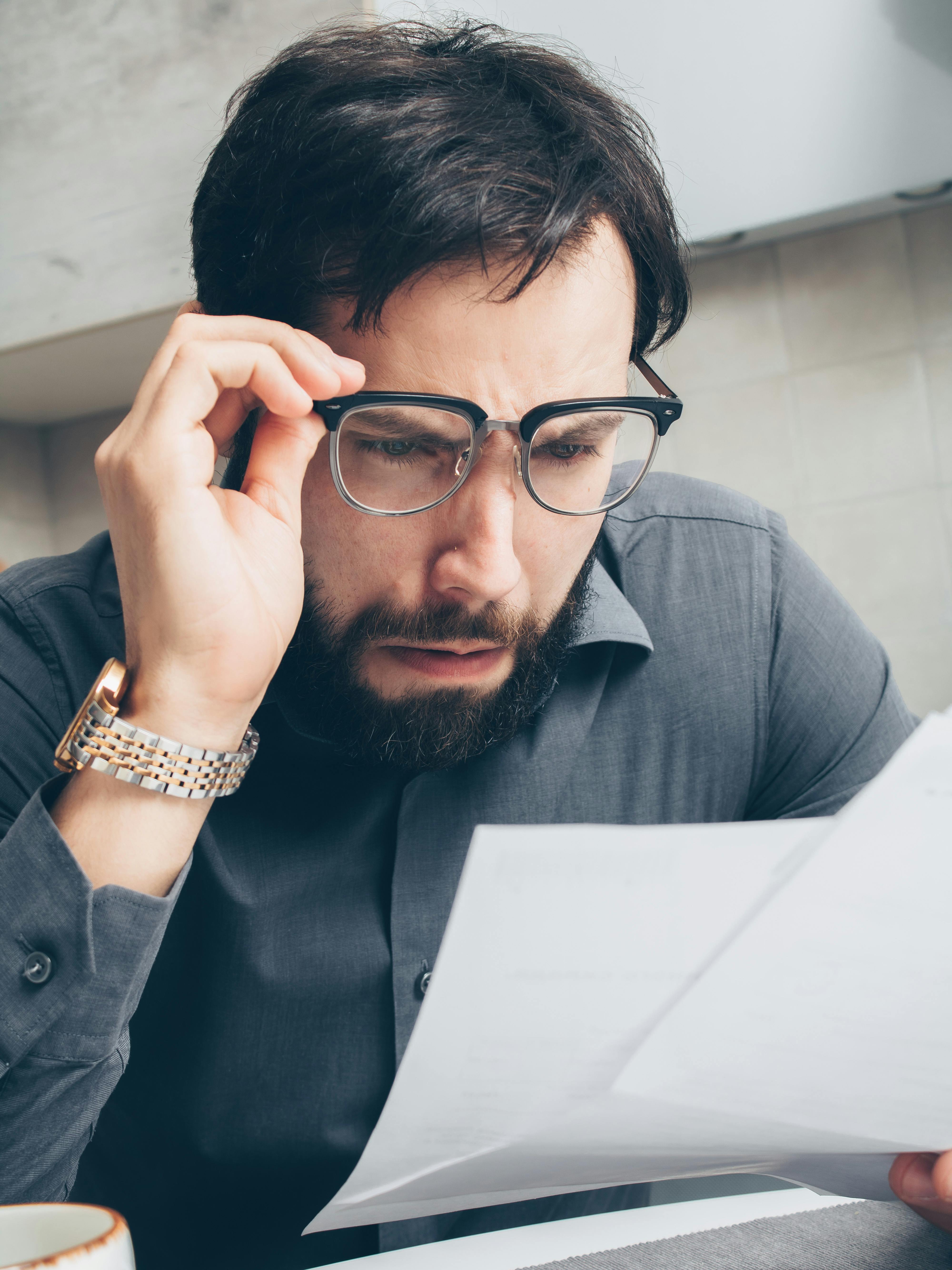 Hombre sorprendido mirando un documento | Fuente: Pexels