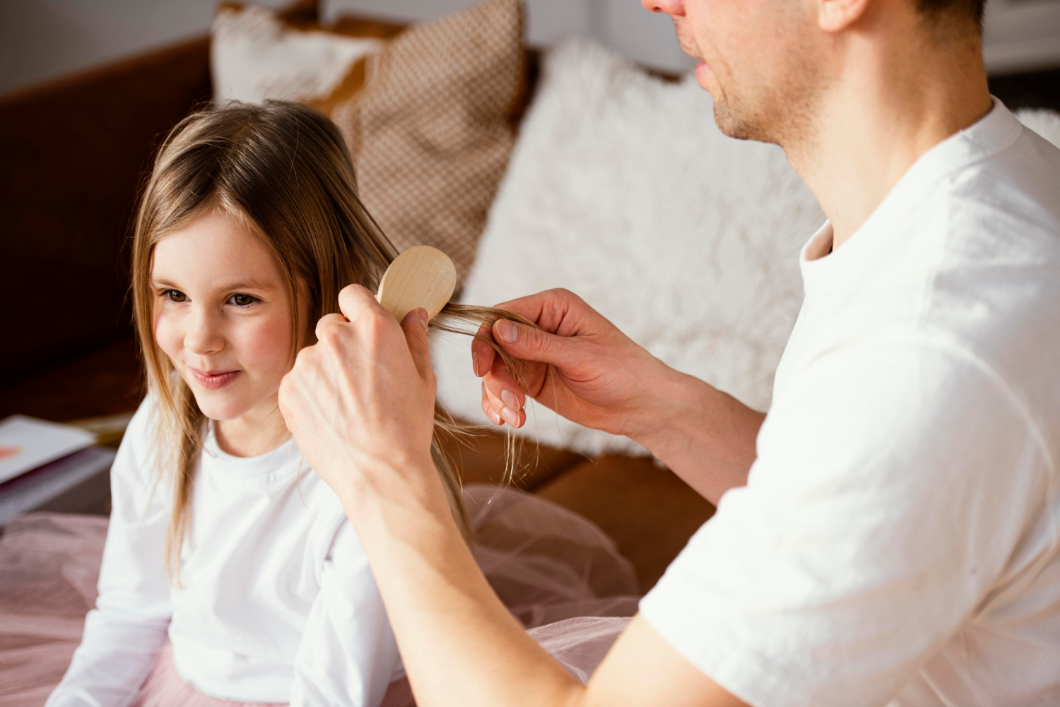 Un hombre cepillando el pelo a su hija | Fuente: Freepik