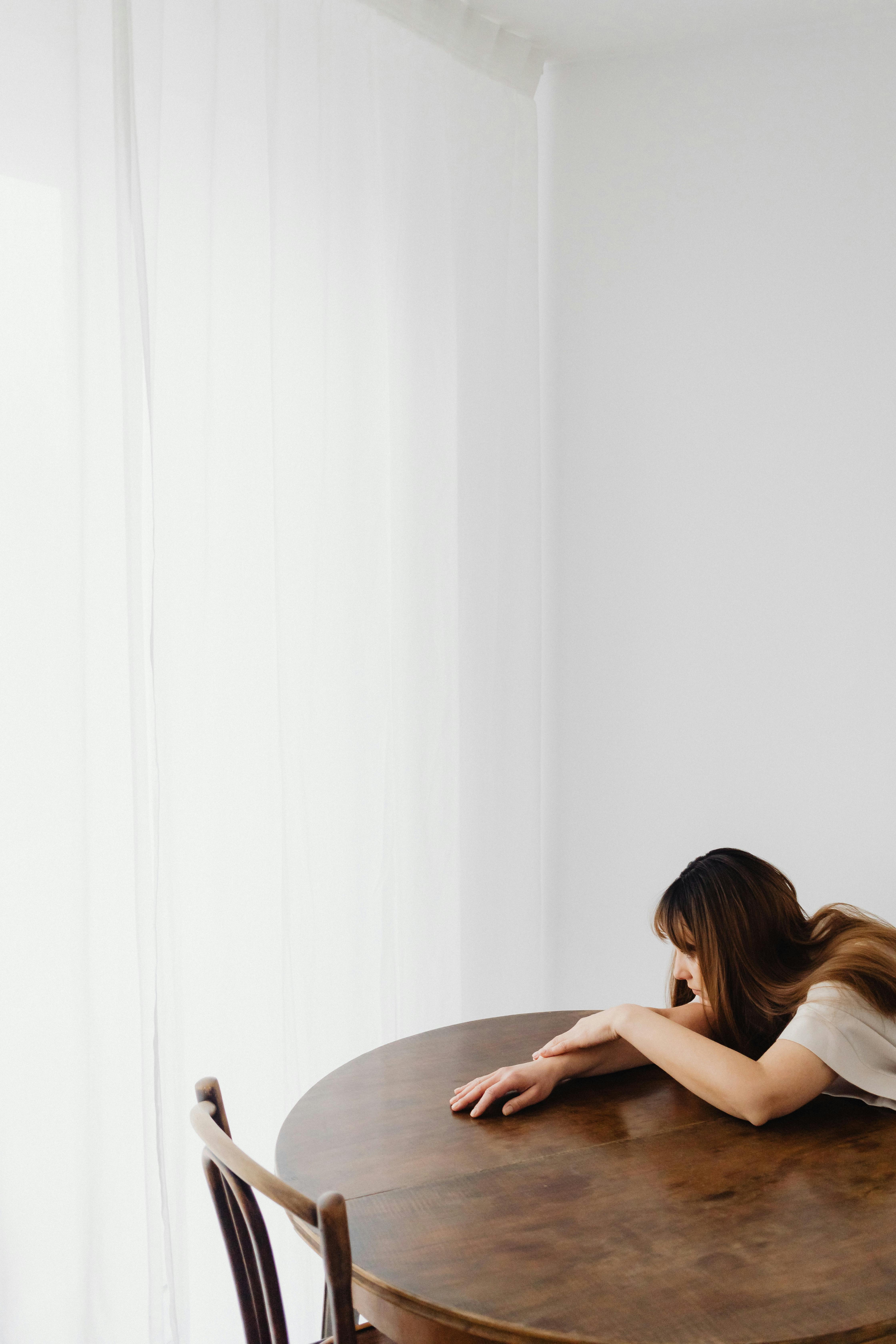 Una mujer apoyada en una mesa | Fuente: Pexels