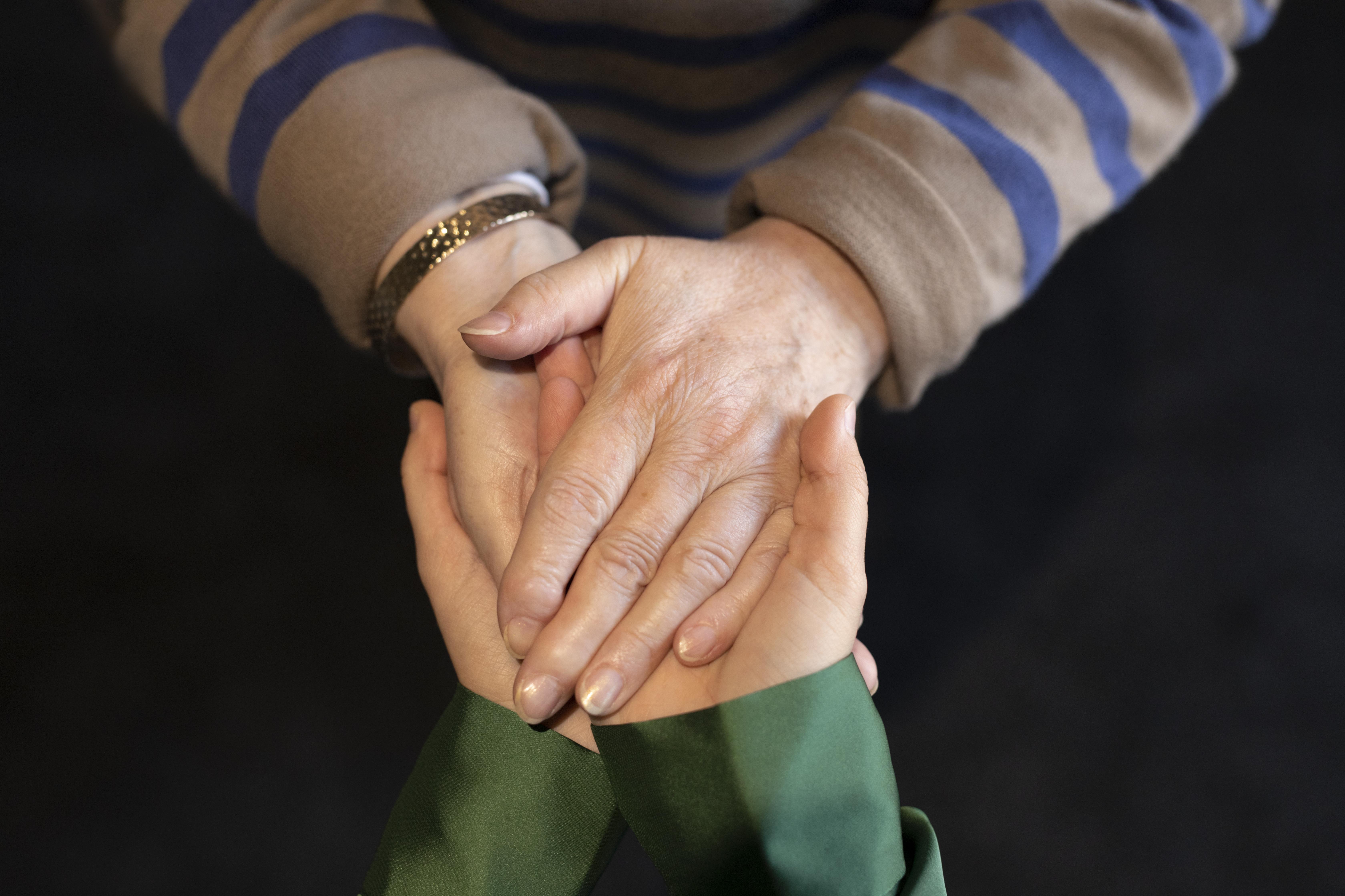 Mujer joven y señora mayor tomadas de la mano | Fuente: Freepik