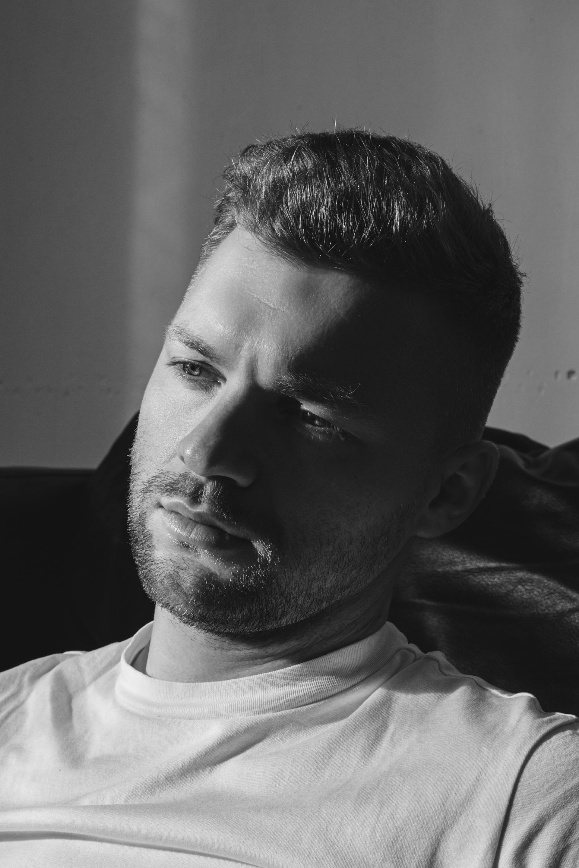 Foto en escala de grises de un hombre con aspecto pensativo | Fuente: Pexels