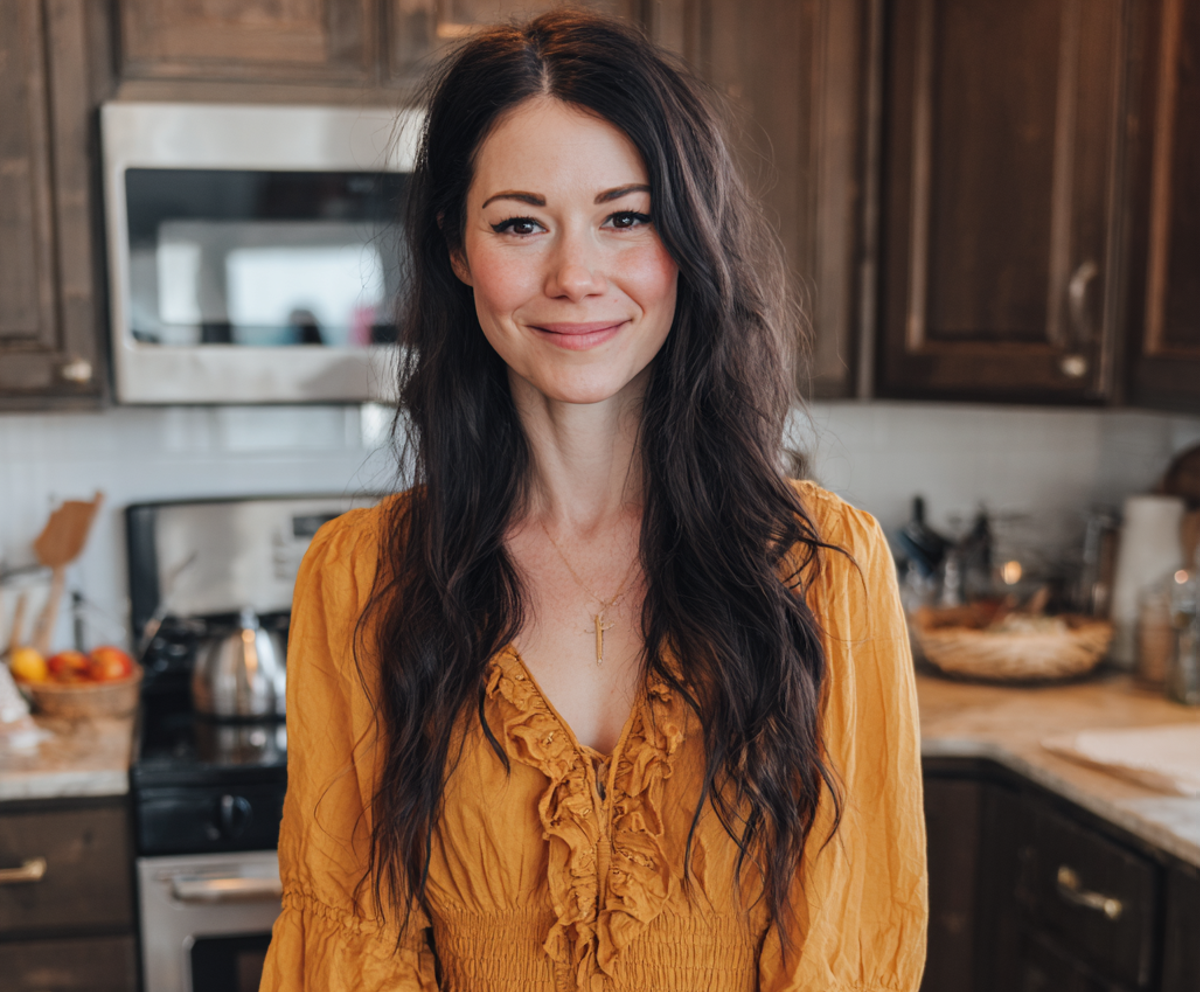 Una mujer sonriente de pie en una cocina | Fuente: Midjourney